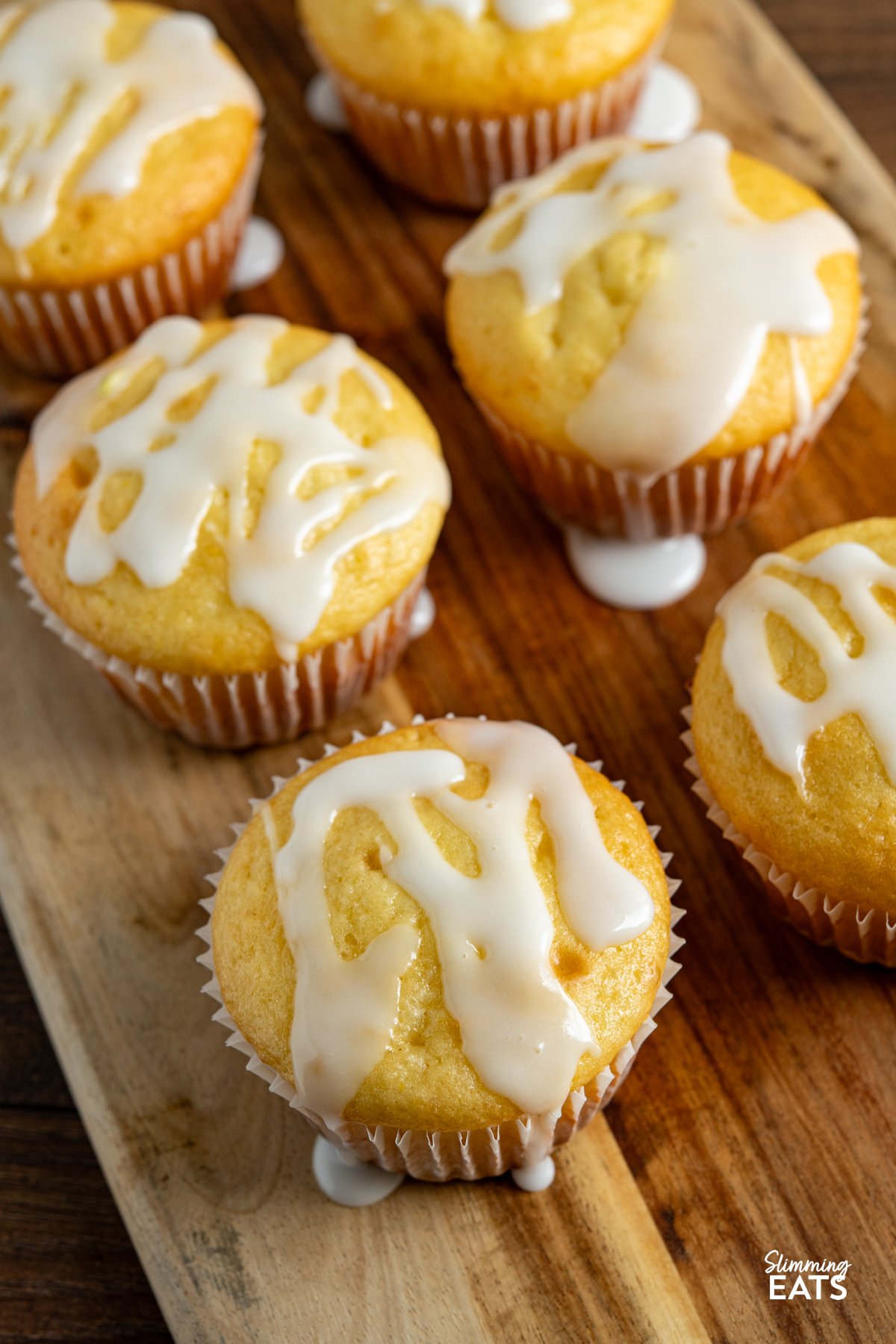 These Lemon Drizzle Muffins are a light and zesty treat that deliver all the flavour of a classic bake without the extra calories. close up of Lemon Drizzle Muffins on a wooden board