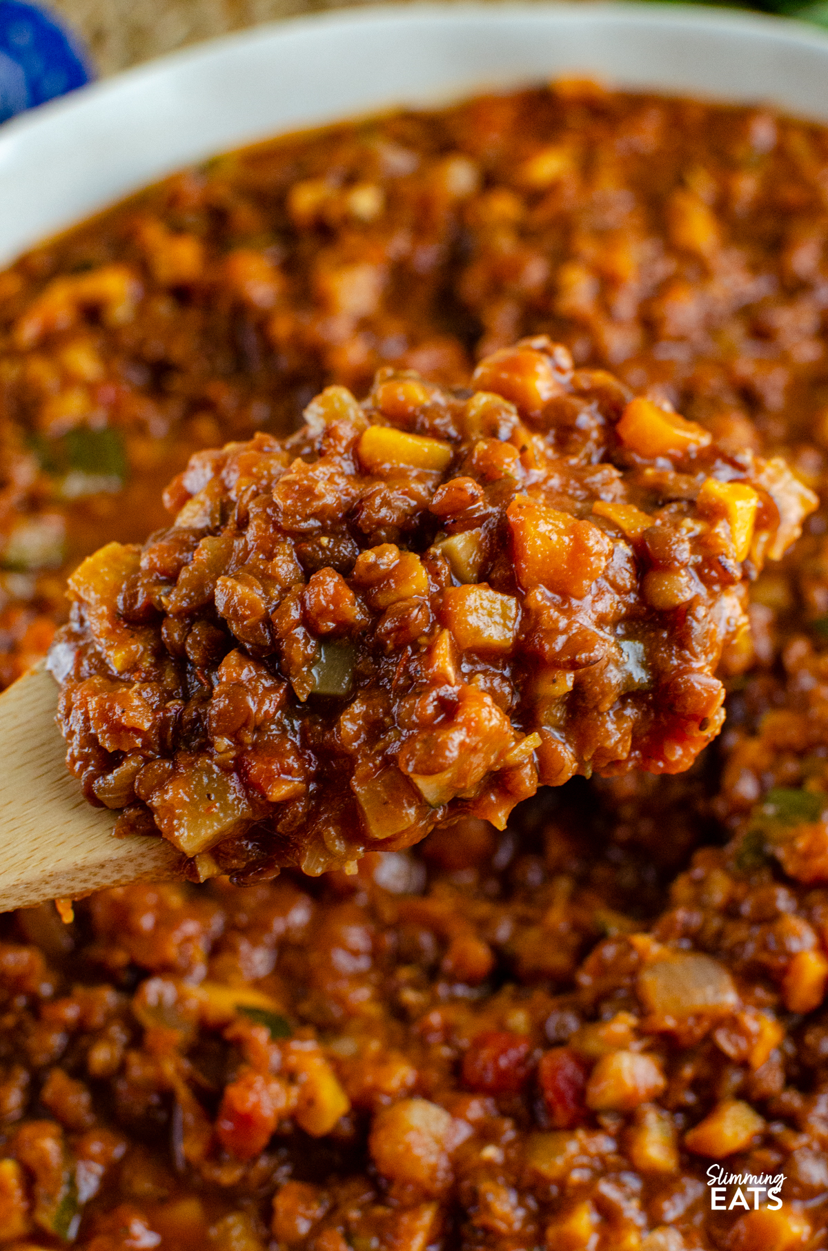 Lentil Bolognese - a hearty comforting meat free bolognese packed with lentils, vegetables and rich tomato flavour that is perfect for family dinners and batch cooking. It is filling, budget friendly and a great way to turn a simple bag of lentils into something really delicious. Lentil Bolognese being spooned out of a dish