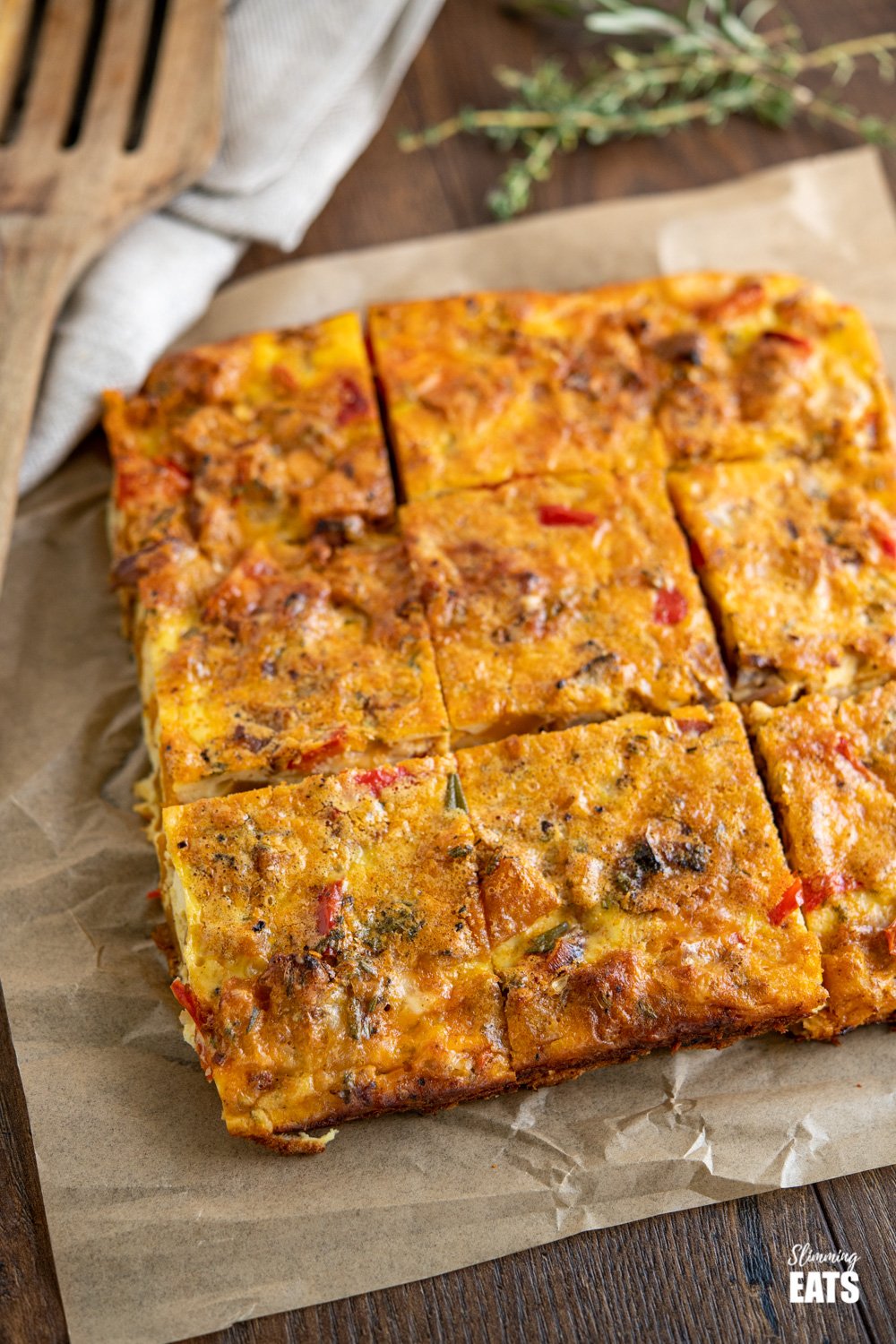 Roasted Butternut Squash and Red Pepper Quiche - Plate up a slice of this delicious crustless quiche with vegetables, fresh herbs, parmesan and cheddar. Slimming Eats and Weight Watchers friendly. #glutenfree #quiche #eggs #butternutsquash #vegetables sliced roasted butternut squash and red pepper quiche on parchment paper