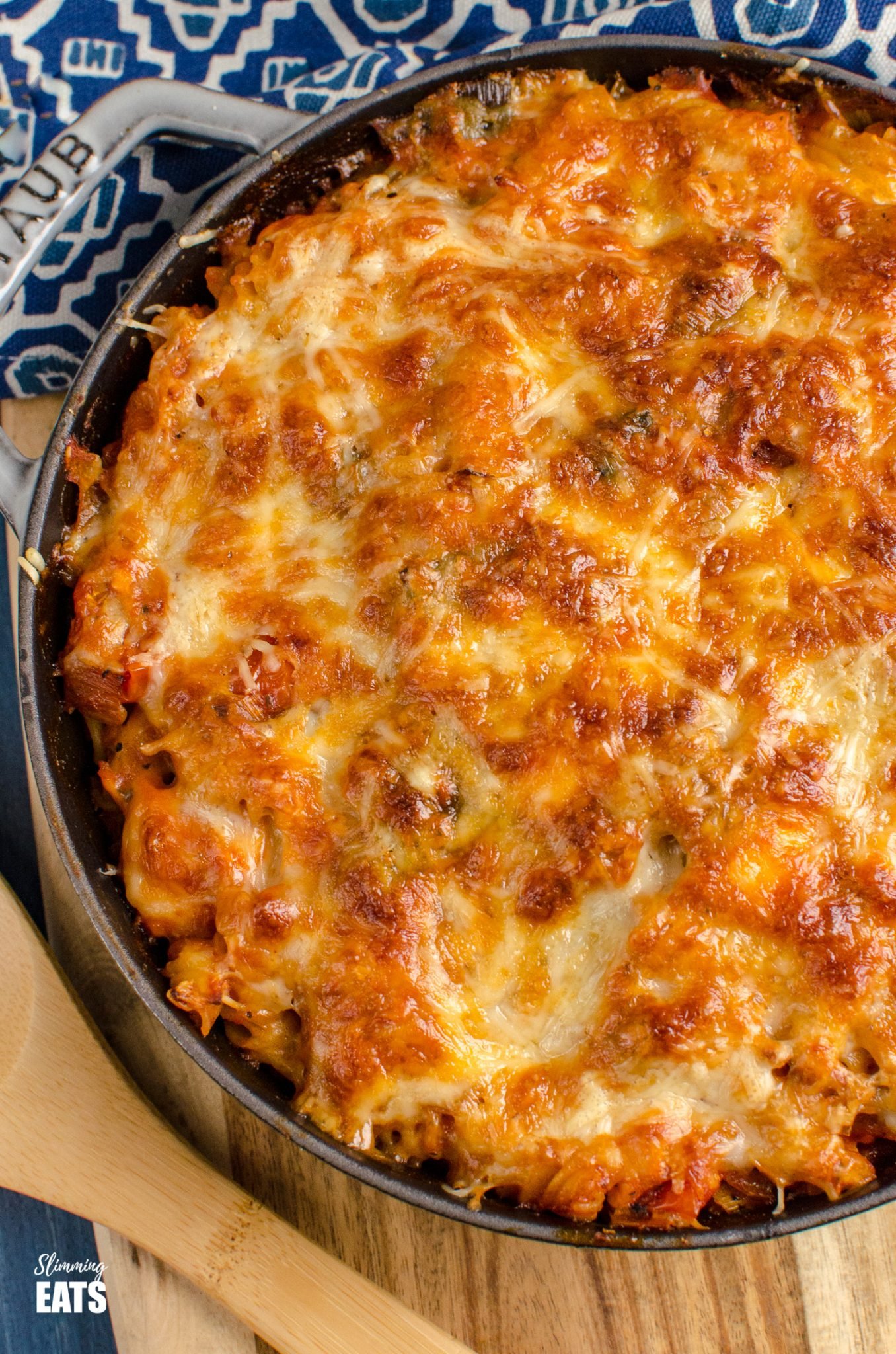 Salmon and Leek Pasta Bake - Salmon and Leek Pasta Bake - a delicious recipe using fresh salmon, sauteed leeks and a homemade tomato pasta sauce, all finished off with melted cheesy goodness - yum!! Slimming World and Weight Watchers friendly close up of Salmon and Leek Pasta Bake is grey cast iron Staub skillet