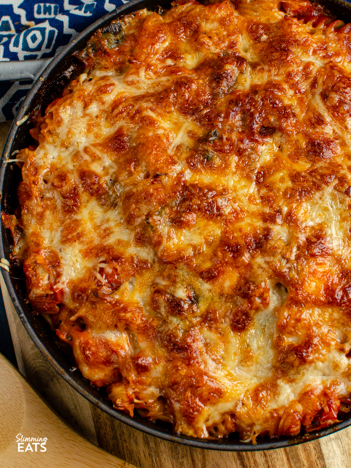 Salmon and Leek Pasta Bake - Salmon and Leek Pasta Bake - a delicious recipe using fresh salmon, sauteed leeks and a homemade tomato pasta sauce, all finished off with melted cheesy goodness - yum!! Slimming Eats and Weight Watchers friendly close up of Salmon and Leek Pasta Bake is grey cast iron staub skillet