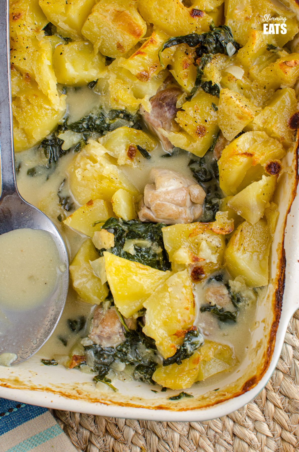 close up of Creamy Chicken and Spinach Pie in oven dish with portion removed