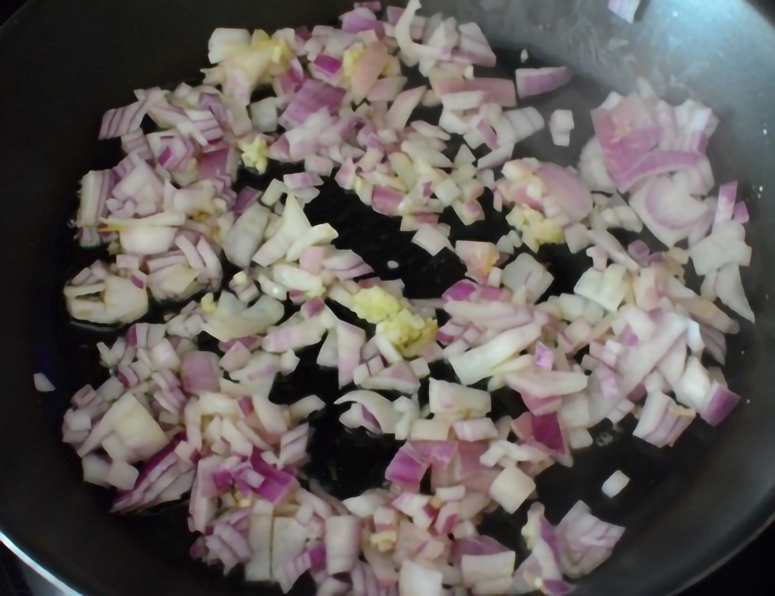 ONIONS BEING SAUTEED IN A PAN