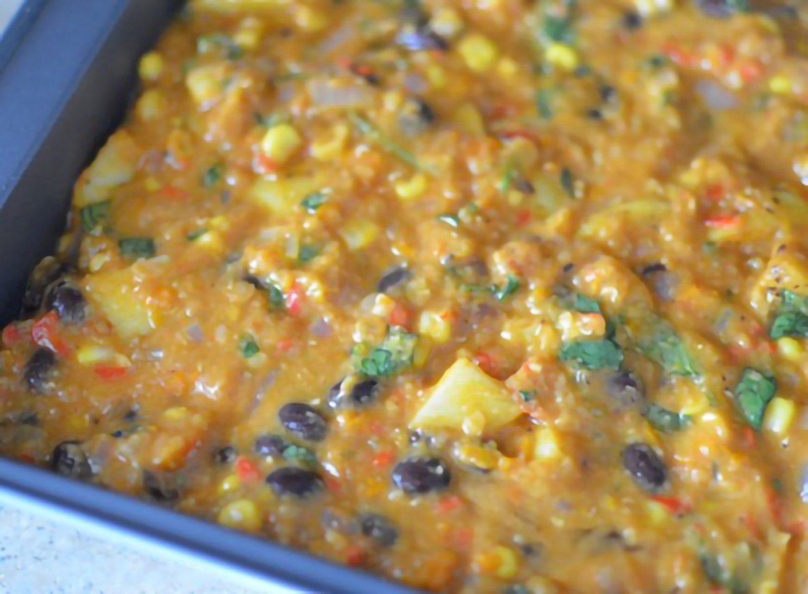 mexican lentil bake ingredients added to baking dish ready to be baked.