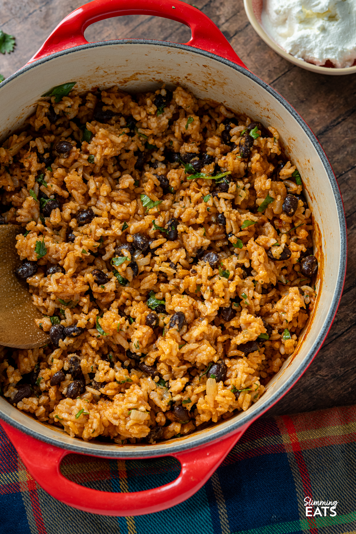 Mexican Rice - a flavour packed rice dish with spicy tomato flavours, black beans and a little kick of jalapeño that makes the perfect side for all your favourite Mexican inspired meals. It is easy to make, full of colour and delicious enough to enjoy all on its own. Mexican rice in cerise cast iron pot with wooden spoon