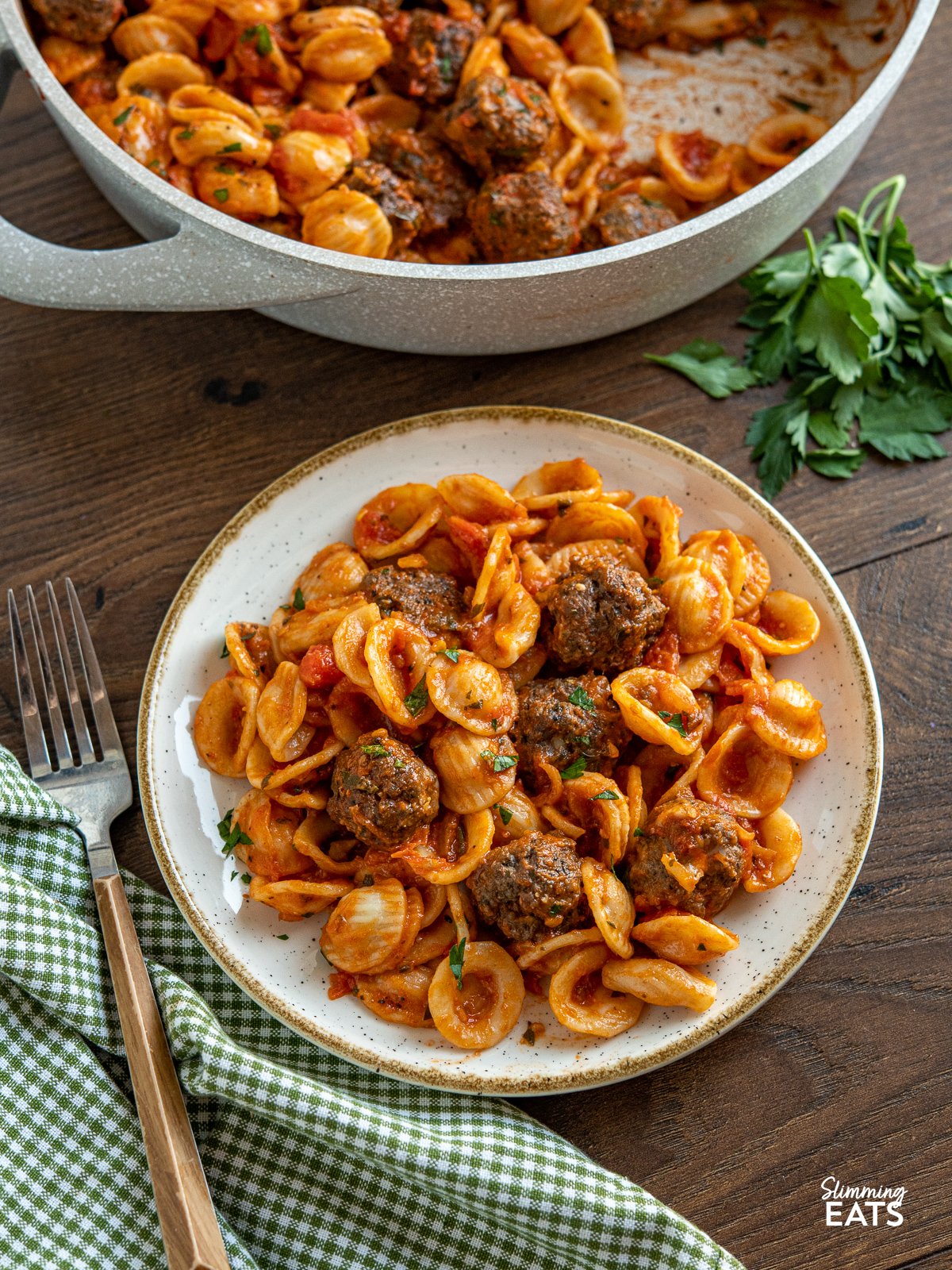 Savoury meatballs with a mixture of ground beef, mushrooms, herbs and parmesan with tender orecchiette pasta in a delicious pasta sauce made from fresh tomatoes and garlic. A hearty comforting meal that is perfect for any occasion. Mini Beef Mushroom Meatballs with Orecchiette on a white plate with tan rim and fork place to left