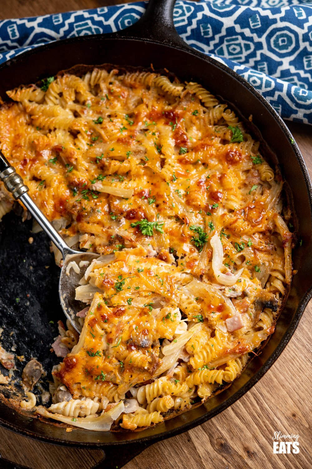 Bacon, Fennel and Mushroom Pasta Bake in a cast iron skillet on wooden board