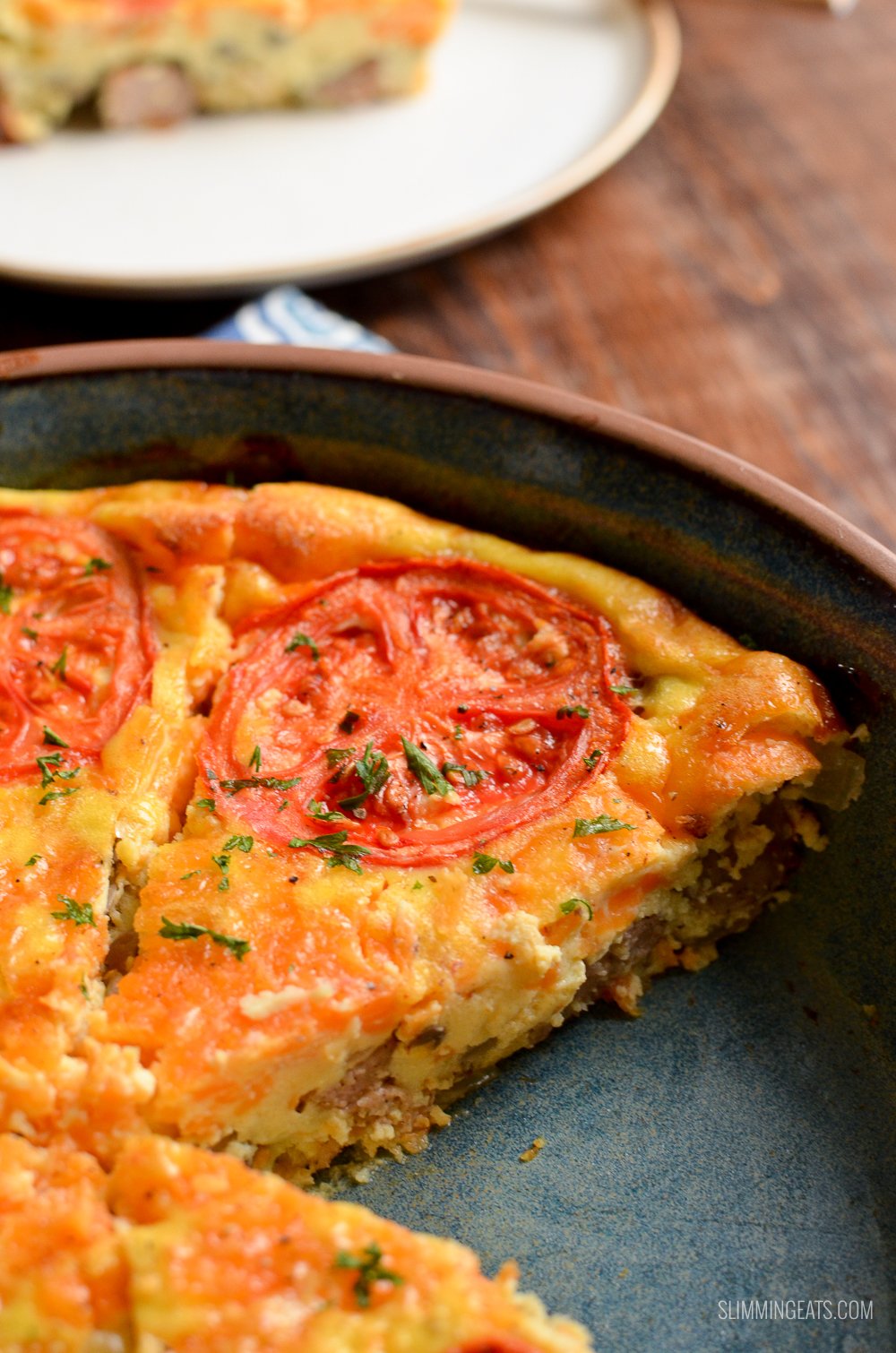 Everything you love about breakfast, all made into this delicious Breakfast Quiche for a quick grab and go breakfast on hectic busy mornings. #slimmingeats #weightwatchers #breakfast #quiche #glutenfree #sausages #cheese #crustless sliced triangle of breakfast quiche in dish