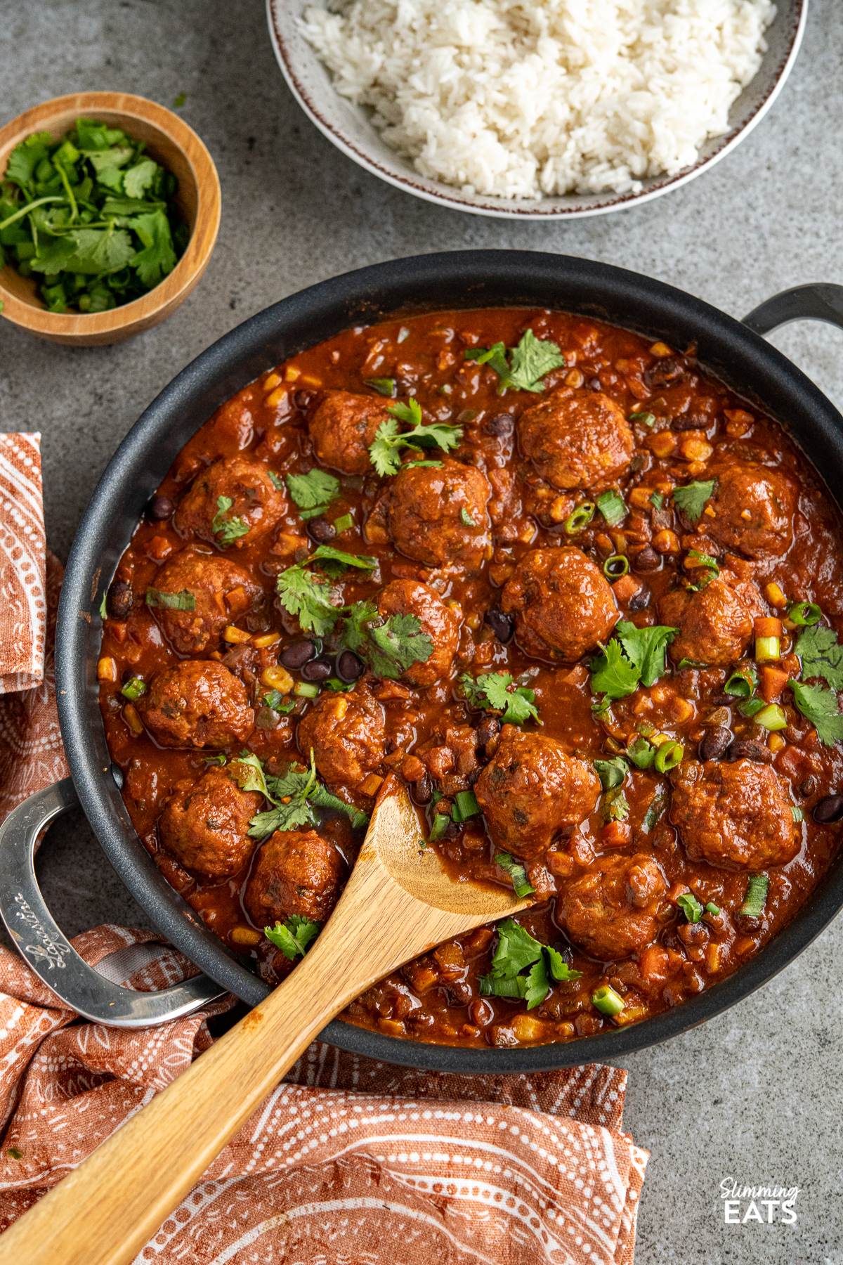 southwestern turkey meatballs in frying pan with double handles, bowl of rice in background
