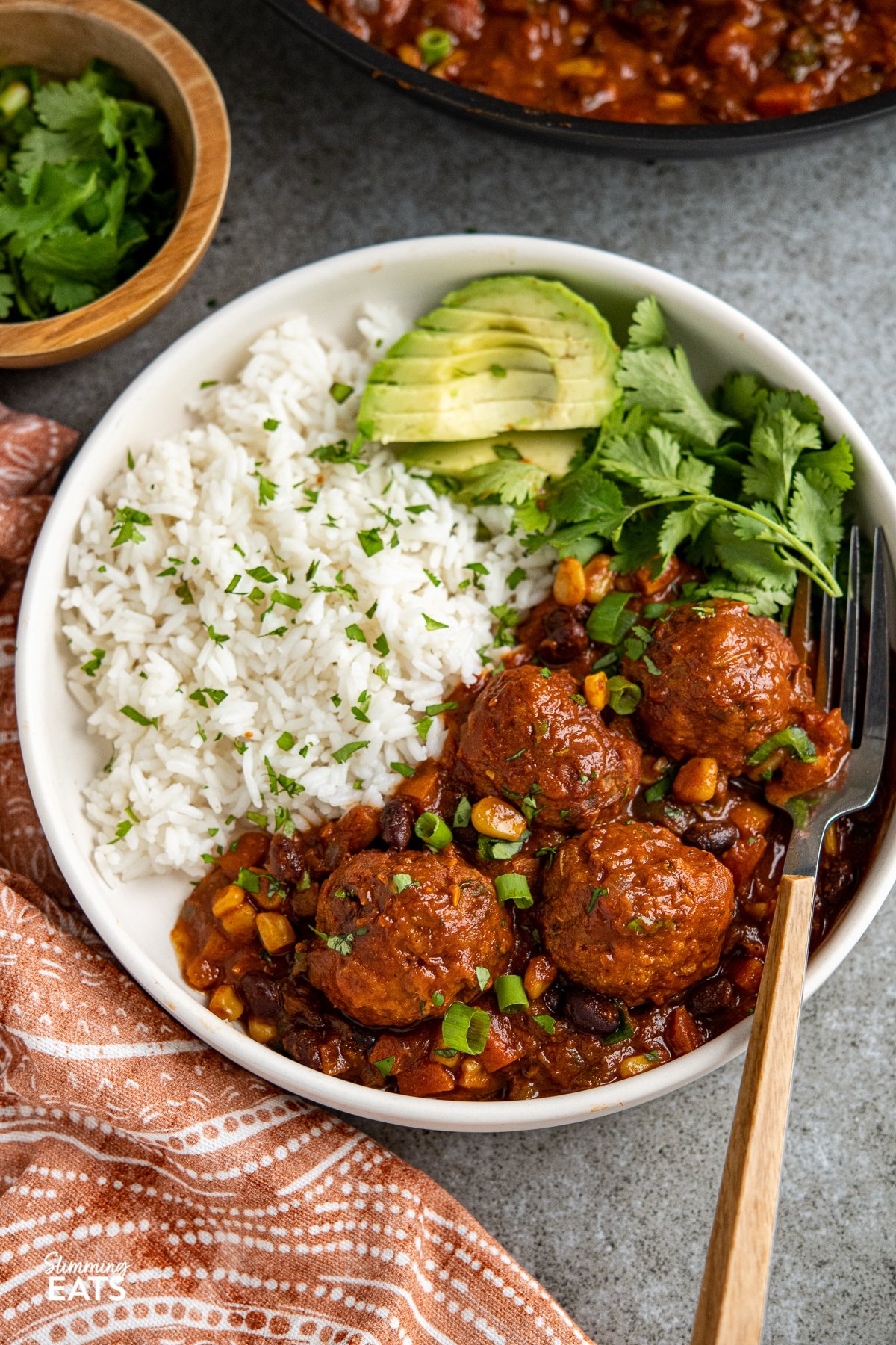 Southwestern turkey meatballs in a bowl with rice, avocado and cilantro