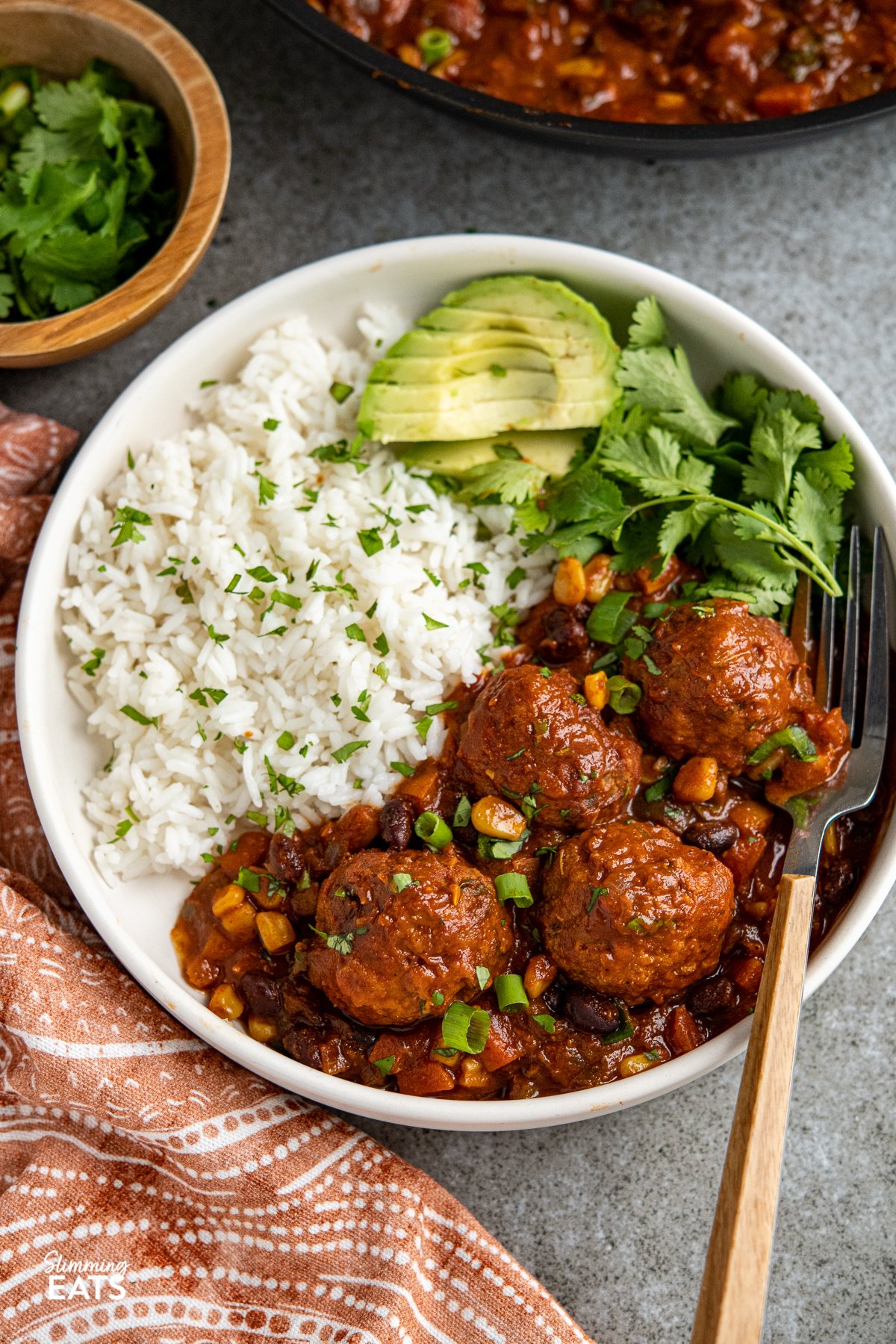 Southwestern Turkey Meatballs - delicious turkey meatballs in a amazing spicy Southwestern Style Sauce with black beans, corn and veggies. Low Calorie and Slimming Friendly Southwestern turkey meatballs in a bowl with rice, avocado and cilantro