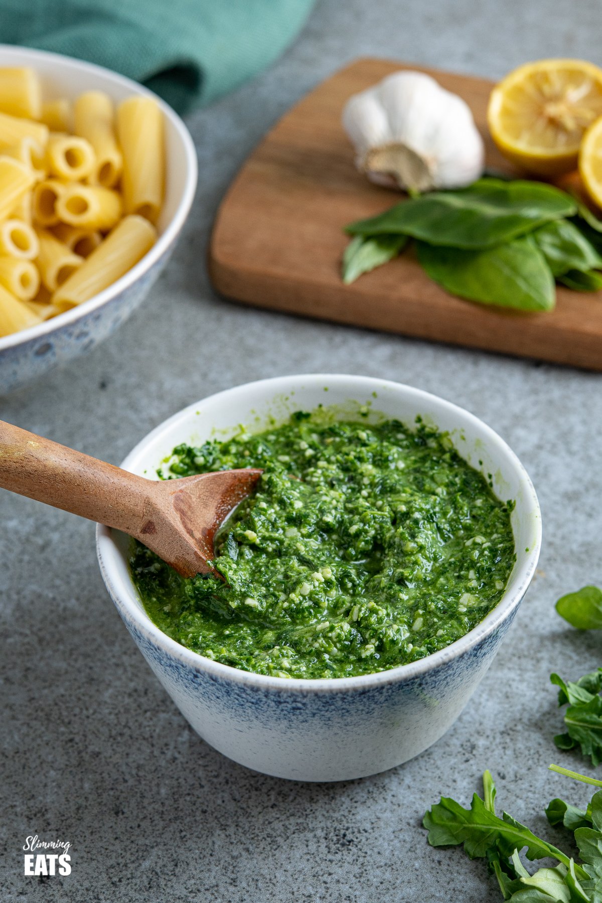 wooden spoon in bowl of skinny pesto