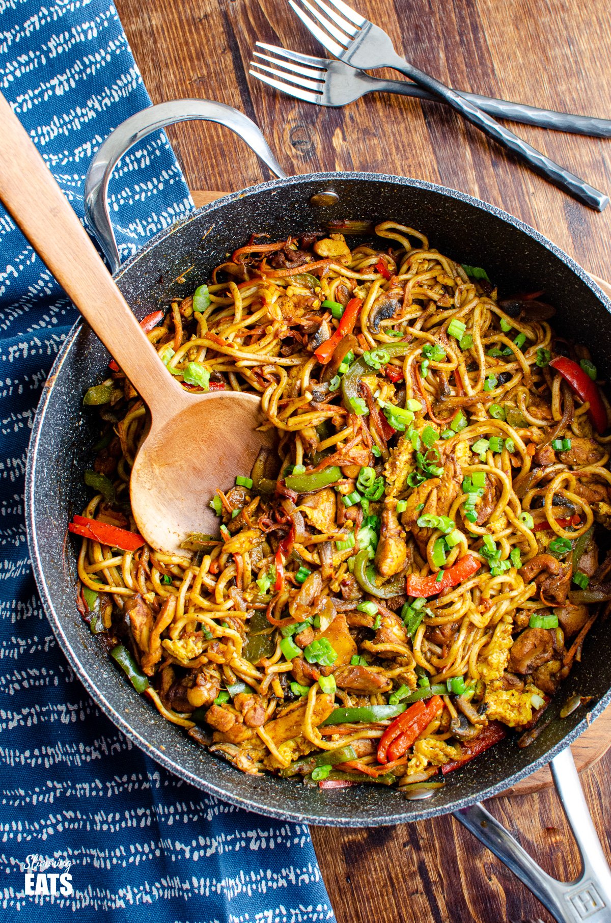 Delicious Singapore Chicken Noodles in a frying pan with wooden spoon