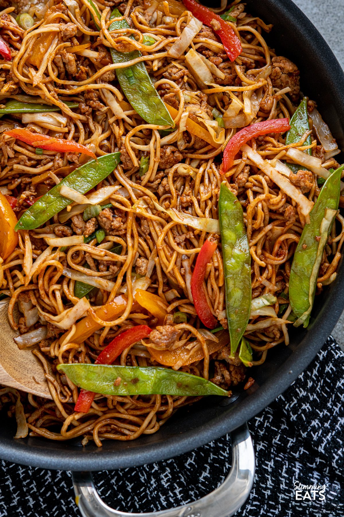 close up of Hoisin Pork and Noodles  in black two handled frying pan