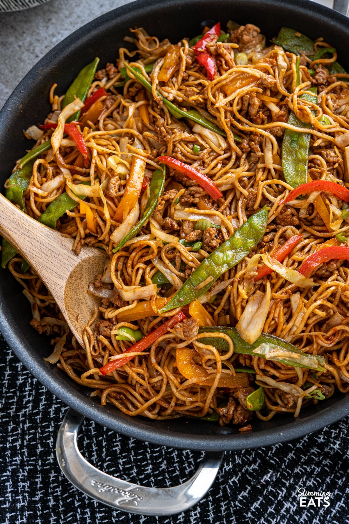 close up of Hoisin Pork and Noodles  in black two handled frying pan