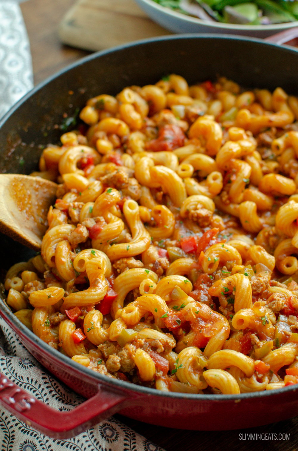 sausage and tomato pasta in a red stab cast iron skillet