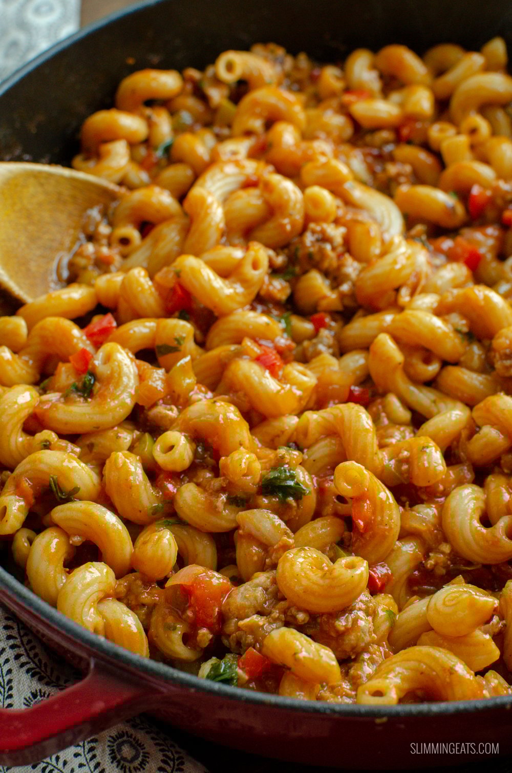 Sausage and Tomato Pasta - a true family pleasing recipe with yummy sausages, peppers and the delicious natural sweetness of tomatoes.| #sausage #pasta #weightwatchers #smartpoints #dairyfree sausage and tomato pasta with wooden spoon