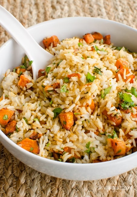 roasted butternut squash rice in a white bowl with spoon as a side to delicious marinated mouth-watering steak