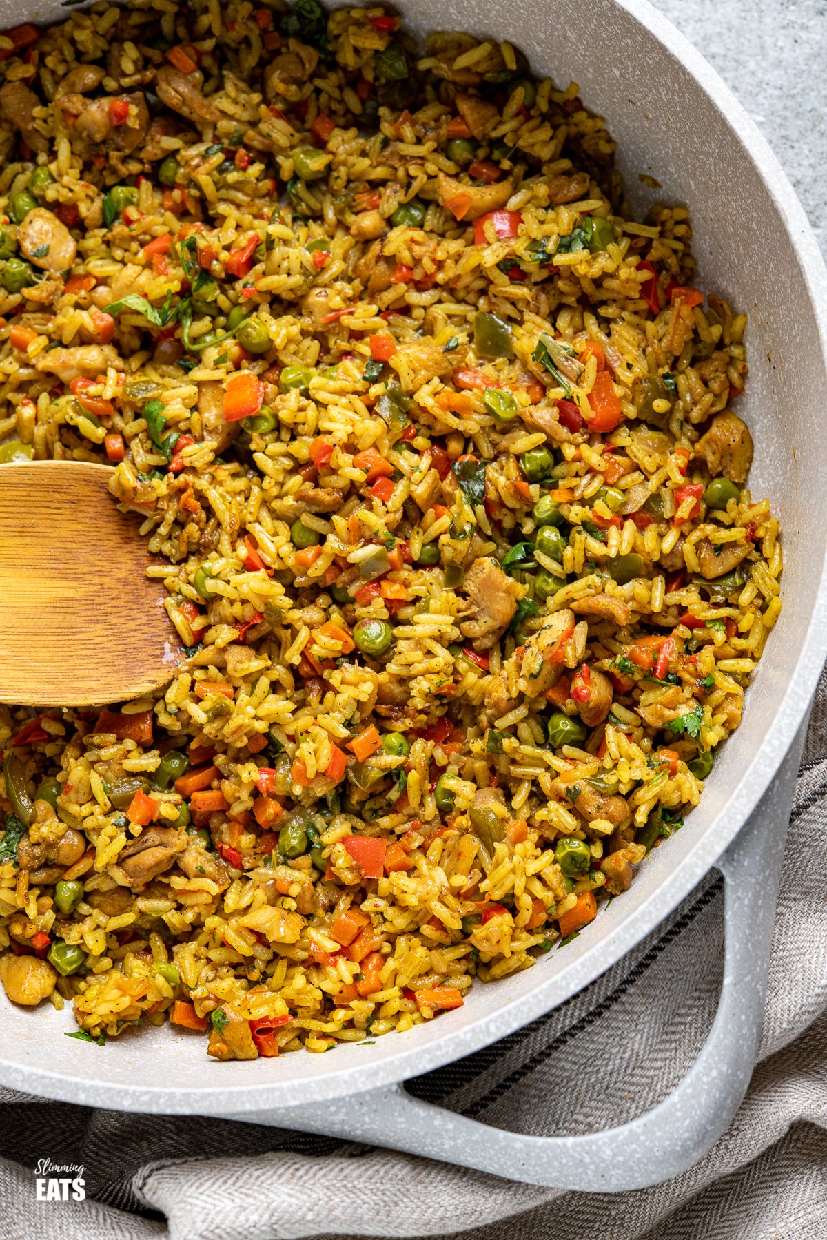 Coconut Chicken Curry Rice in frying pan with wooden spoon