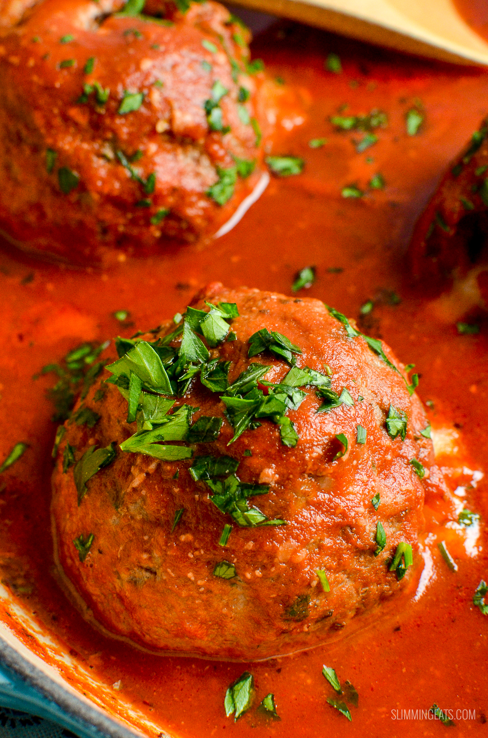 close up of mega stuffed meatball in tomato sauce