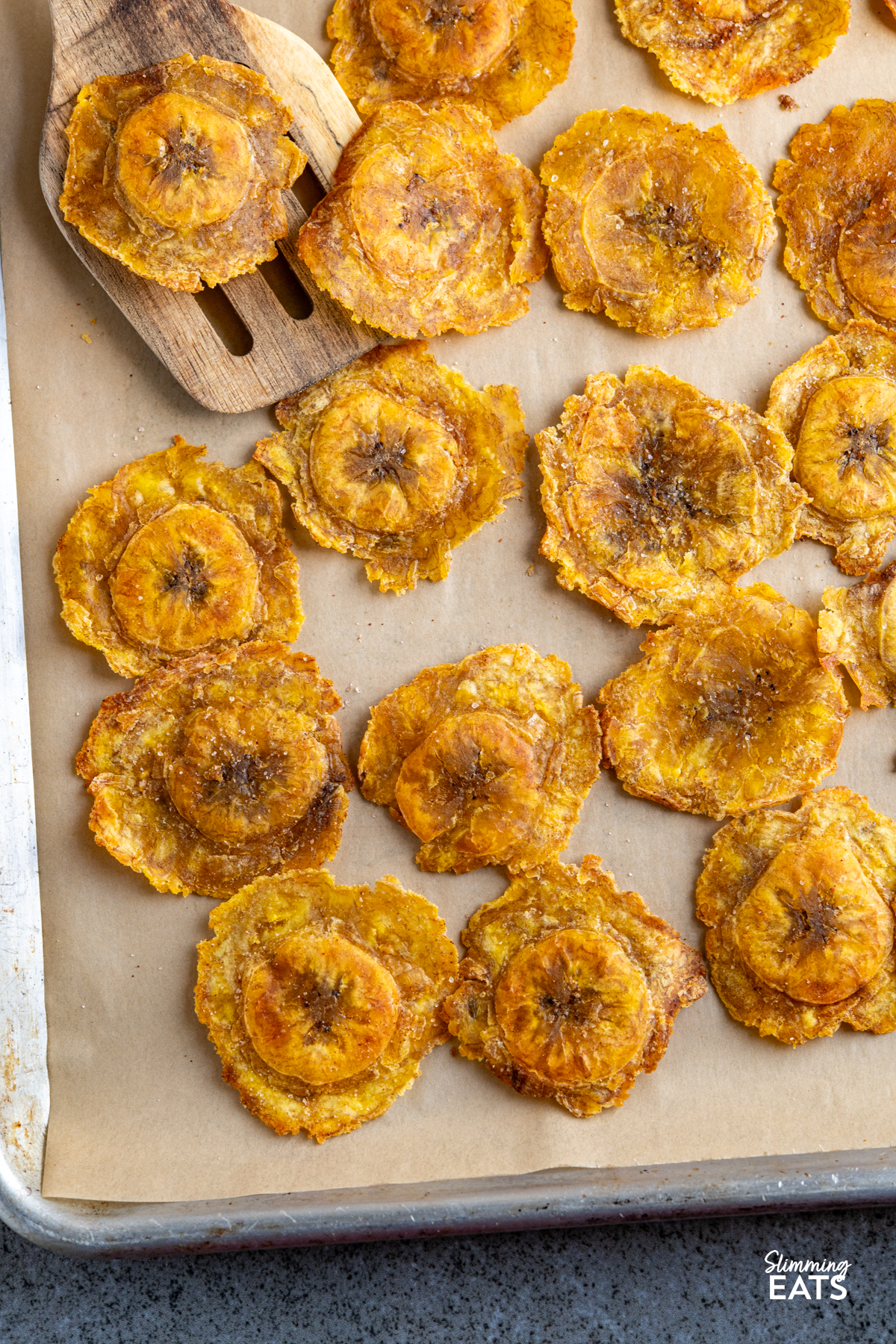 golden baked tostones on a parchment lined baking tray