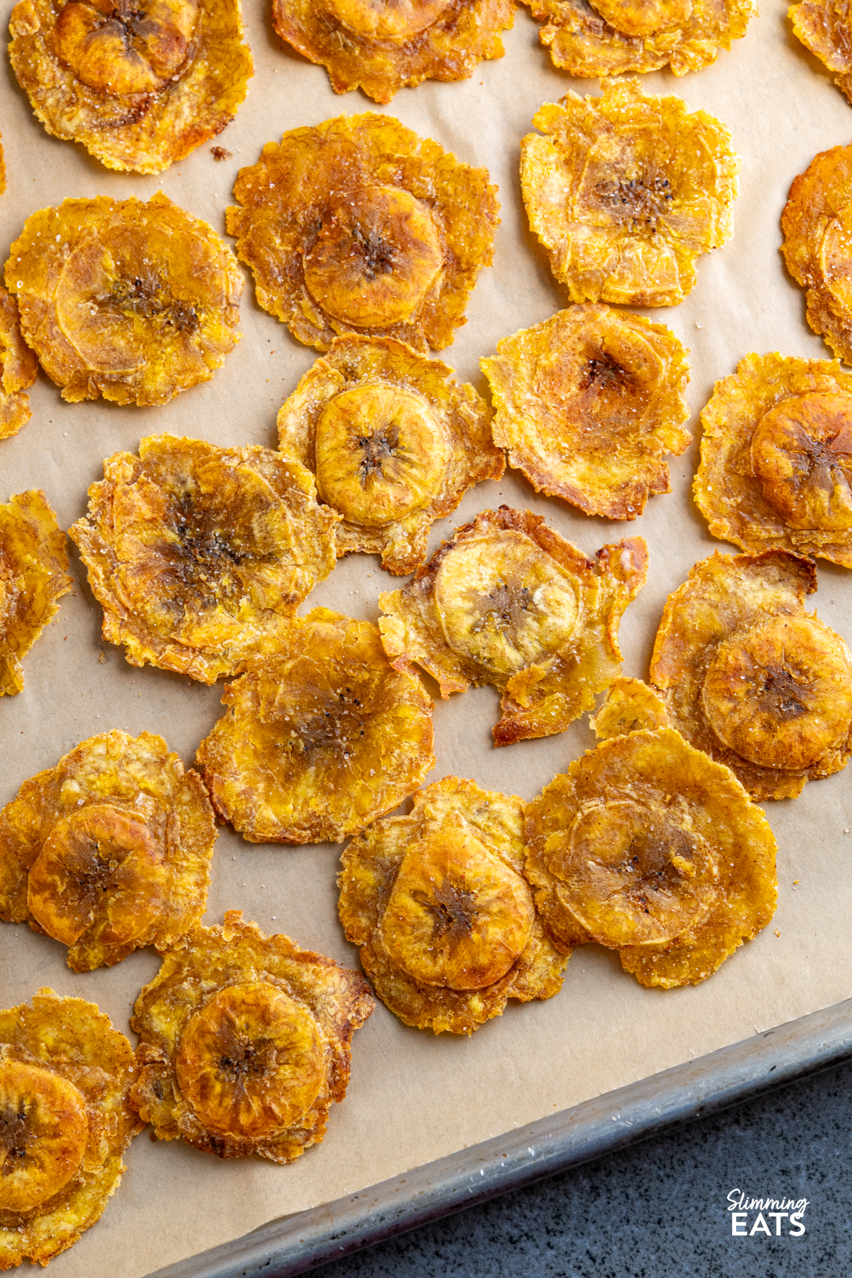 golden baked tostones on a parchment lined baking tray