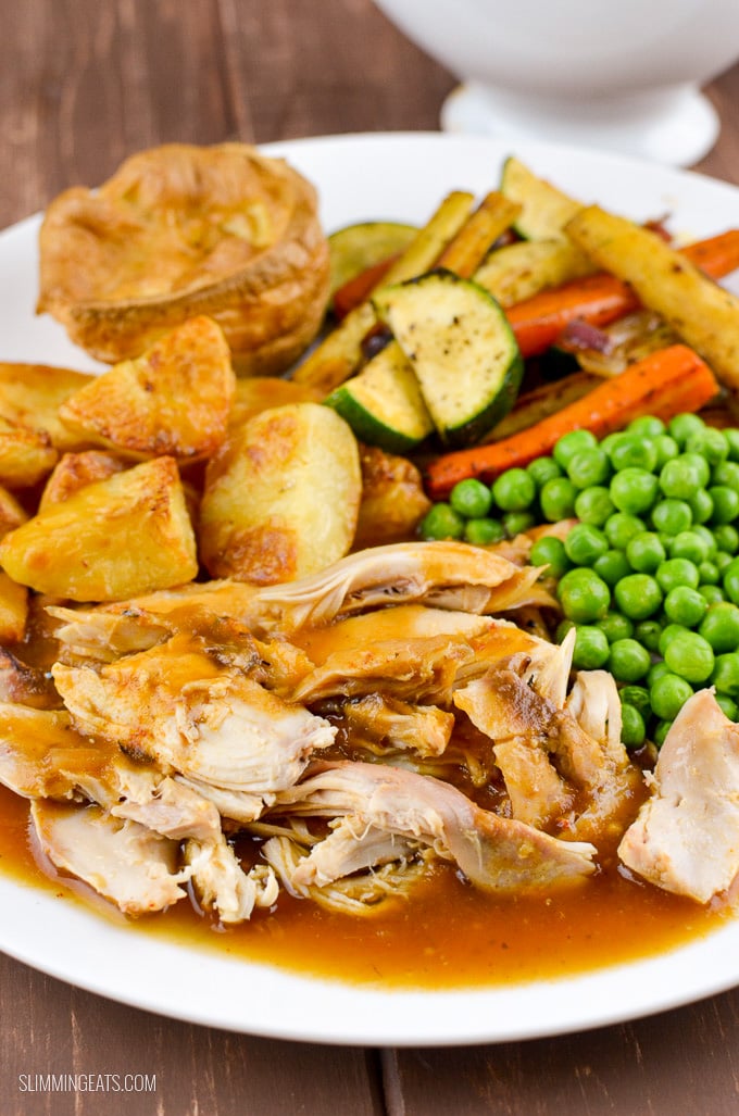 Slow Cooker (Crockpot) Whole Chicken - Amazingly tender Fall off the bone Slow Cooked Chicken with a delicious blend of seasoning!! Gluten Free, Dairy Free, Paleo, Whole30, Slimming Eats and Weight Watchers friendly plated up slow cooked chicken with gravy and roast potatoes, Yorkshire pudding and vegetables