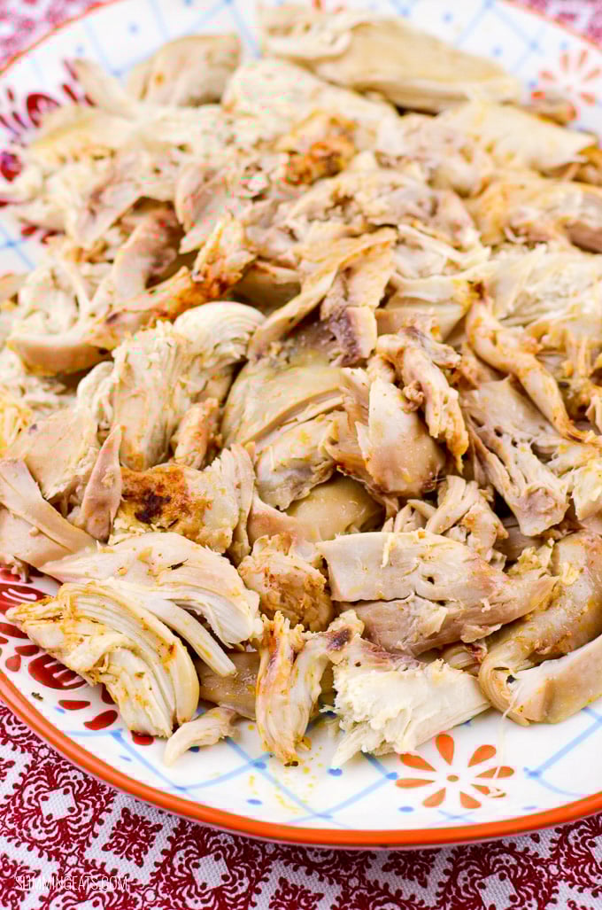 Slow Cooker (Crockpot) Whole Chicken - Amazingly tender Fall off the bone Slow Cooked Chicken with a delicious blend of seasoning!! Gluten Free, Dairy Free, Paleo, Whole30, Slimming Eats and Weight Watchers friendly slow cooked shredded chicken on a oval pattered plate