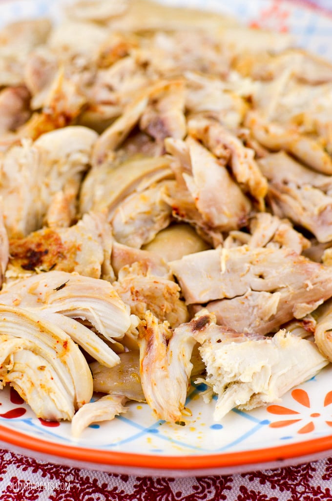 close up of shredded whole slow cooker cooked shredded chicken on a oval plate