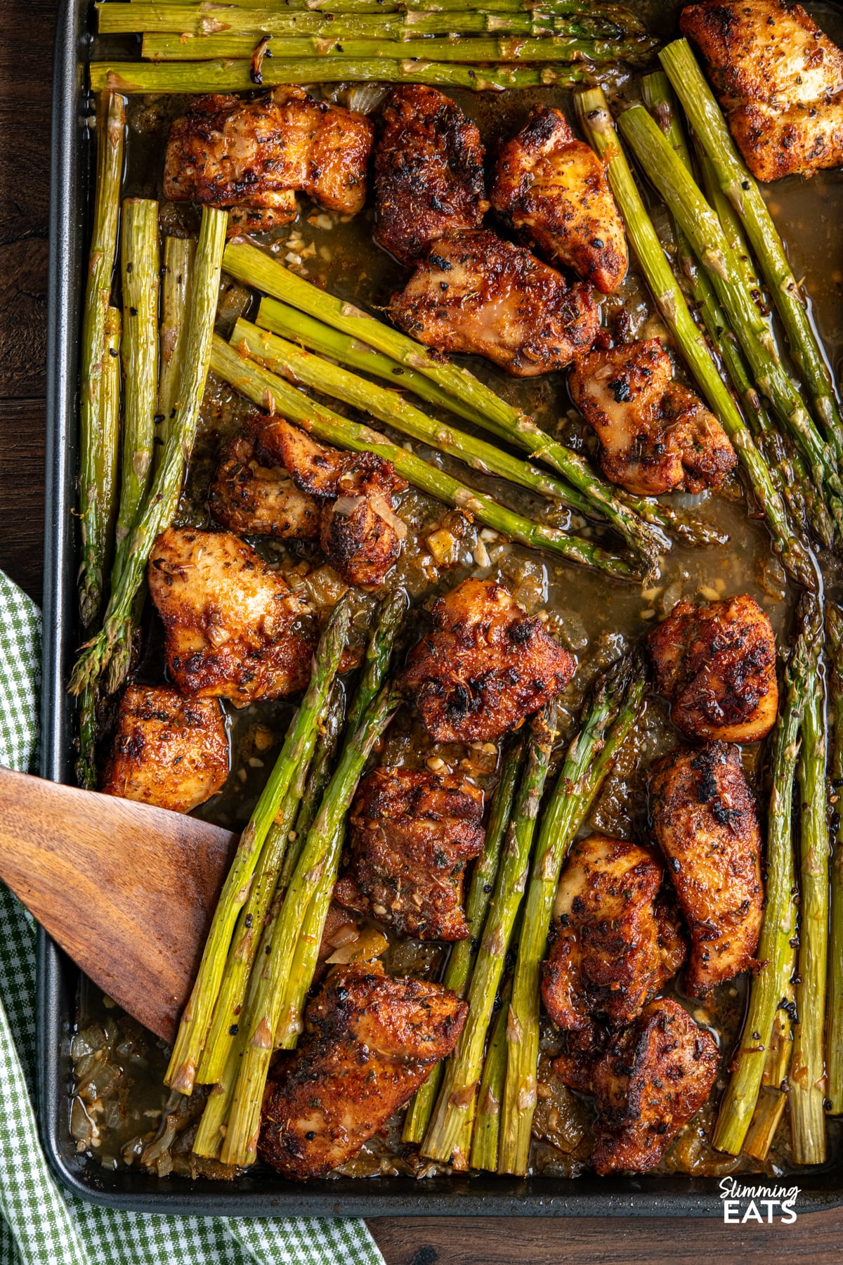 seasoned chicken, asparagus with sauce on a sheet pan