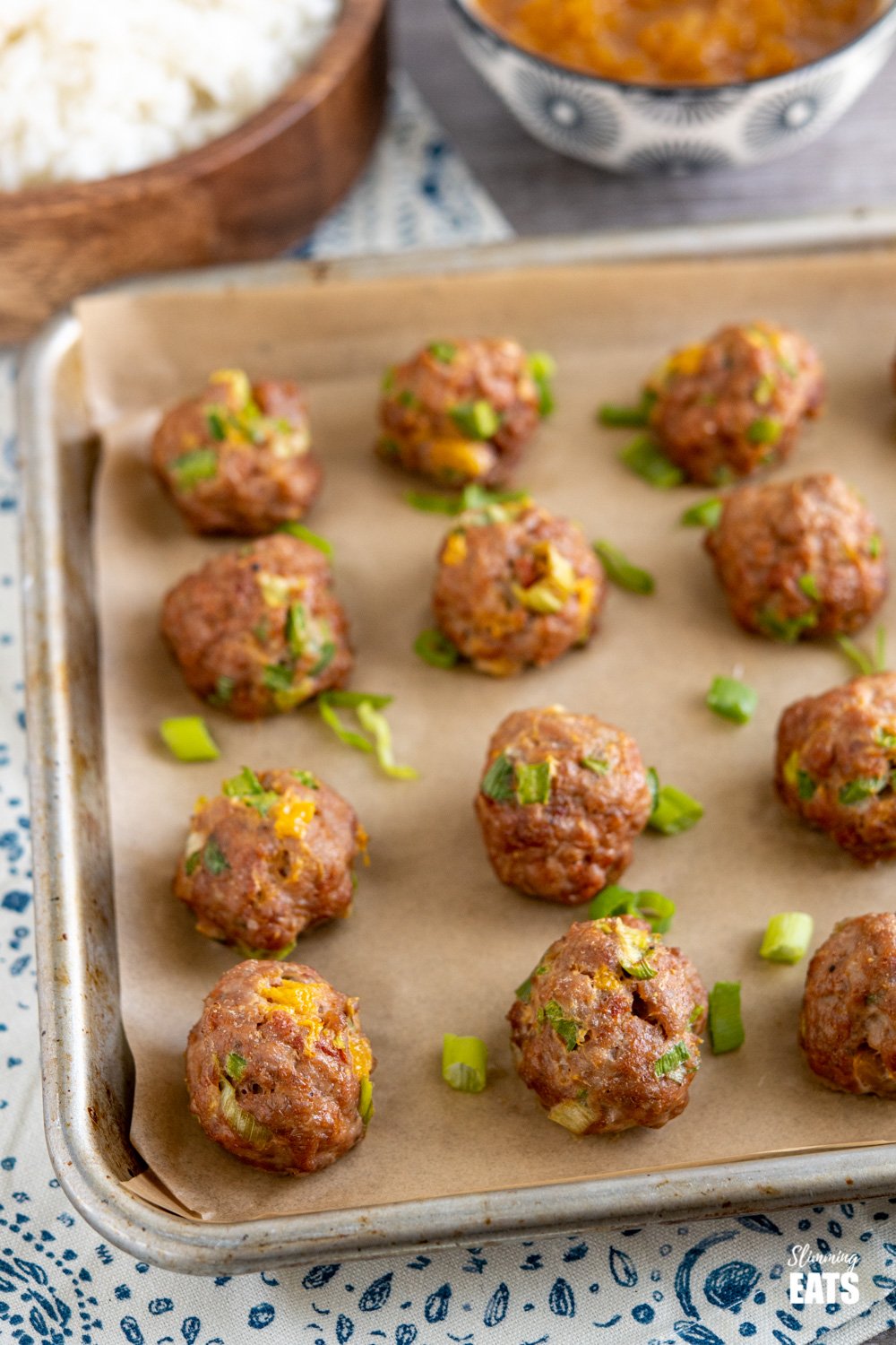 Yummy Tender Chicken and Mango Meatballs with a Spicy Mango Sauce combine both sweet and spicy flavours. A perfect any night of the week meal. Gluten free, dairy free, paleo, Slimming Eats and Weight Watchers friendly chicken and mango meatballs on a parchment lined tray