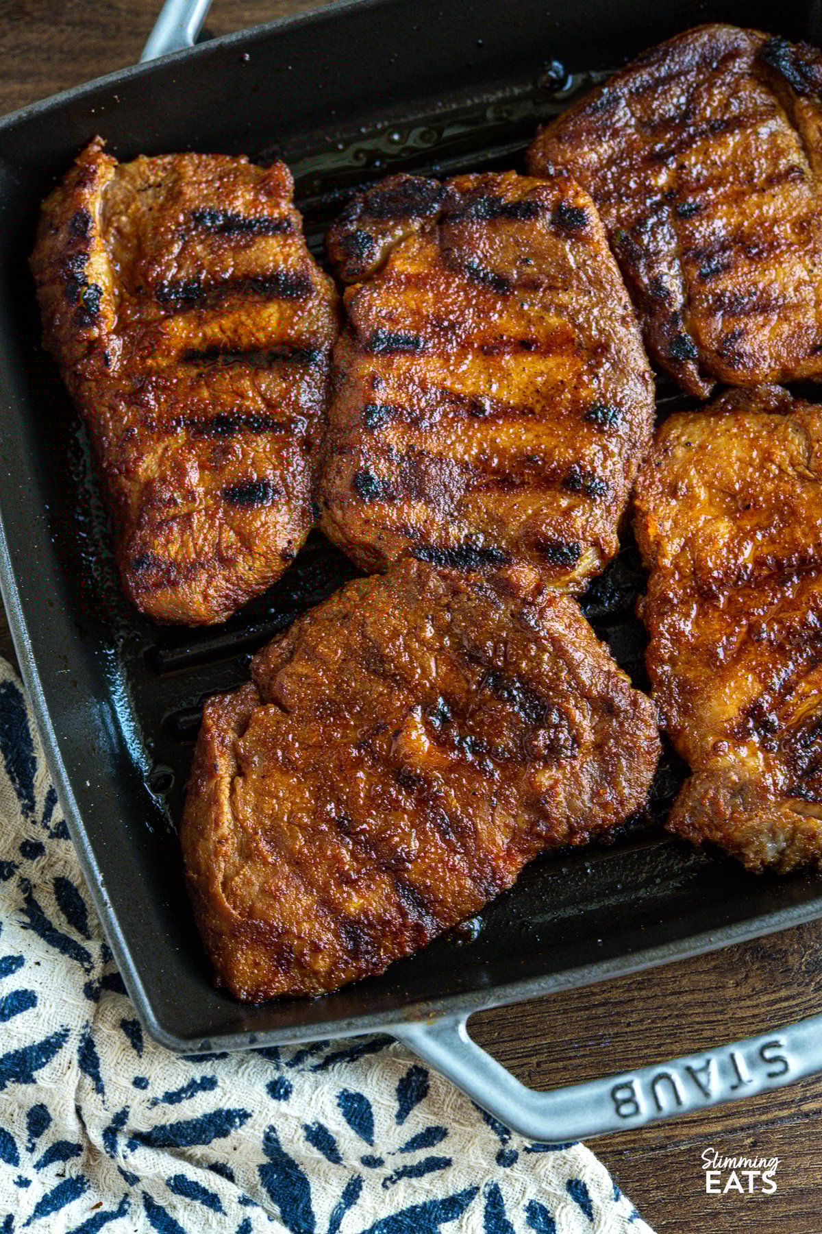 are seasoned to perfection with a homemade BBQ-style spice blend and cooked until lightly golden on a grill pan, ready to be the star of your next meal. close up of grilled bbq pork steaks in grill pan
