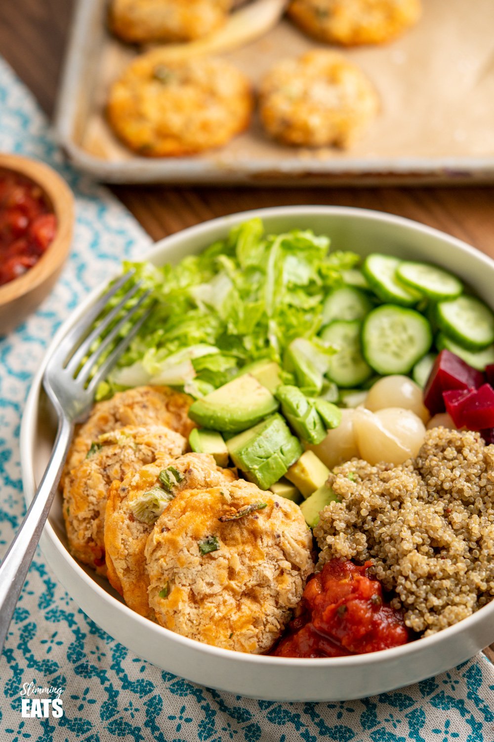 Cheddar Butter Bean Bites in cream bowl with quinoa, cucumber, lettuce, salsa, avocado, beets and picked onions