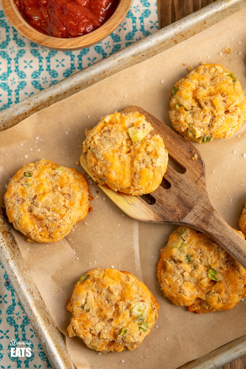 Cheddar Butter Bean Bites - delicious cheesy bites, perfect for dipping, snacking, picnics or lunches. Gluten Free, Vegetarian, Slimming Eats and Weight Watchers friendly cheddar butter bean bites on parchment paper lined baking tray with bowl of salsa above