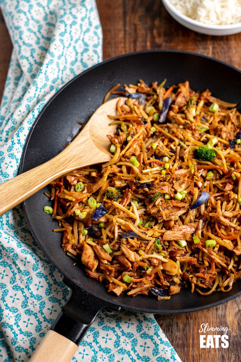 Orange and Ginger Turkey Stir Fry - a simple and flavoursome dish that is perfect for the whole family and ready in minutes. Gluten free, dairy free, Slimming and Weight Watchers friendly orange and ginger turkey stir fry in a black frying pan with wooden spoon