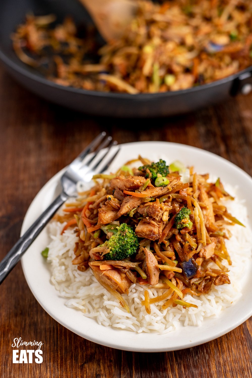 orange and ginger turkey stir fry with rice on white place with fork