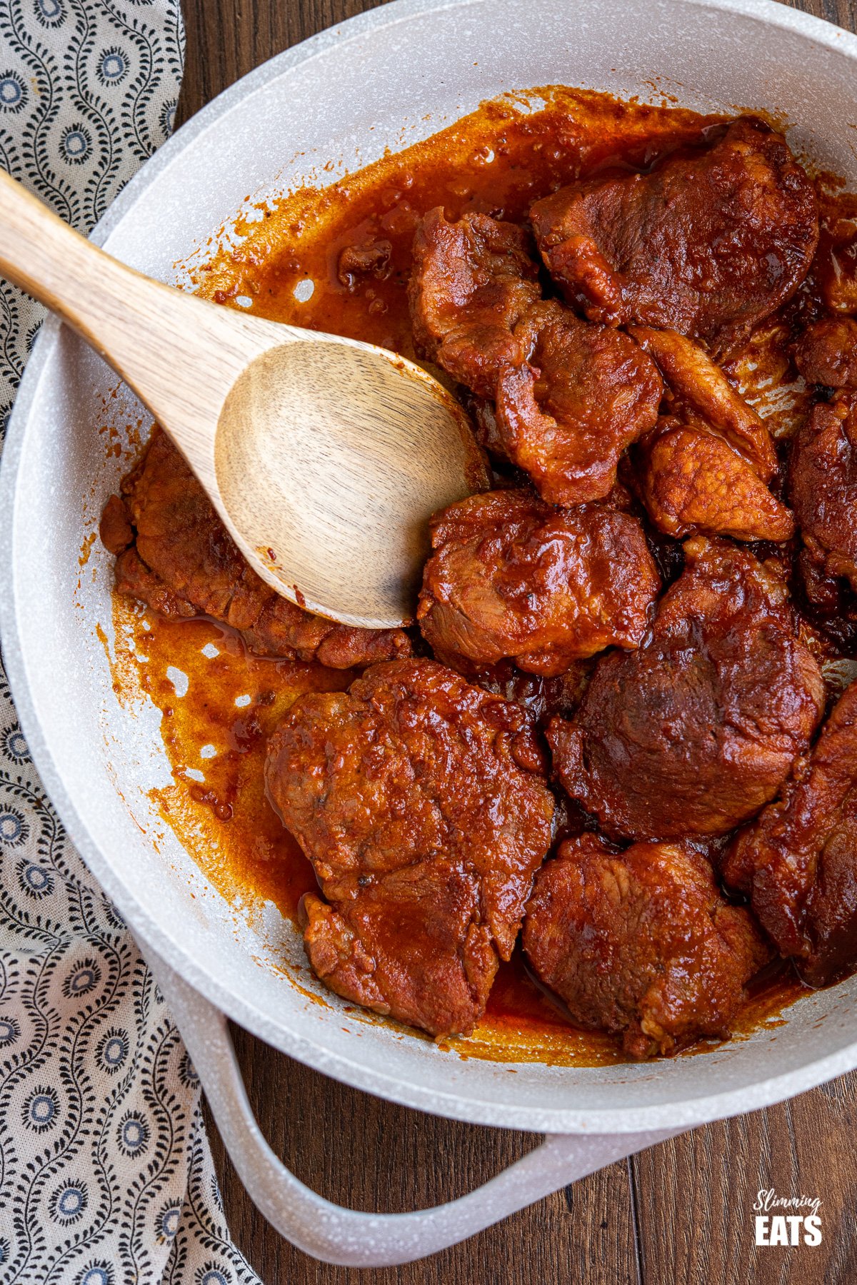 stove top bbq pork in pan with wooden spoon