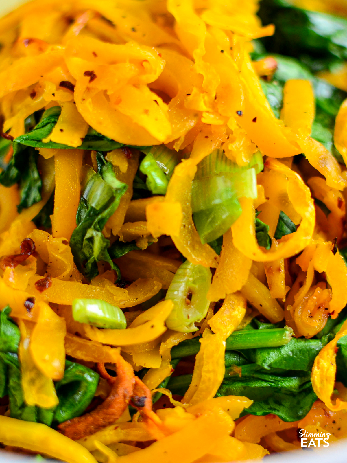 close up of oven baked butternut squash noodles with spinach and spring onions
