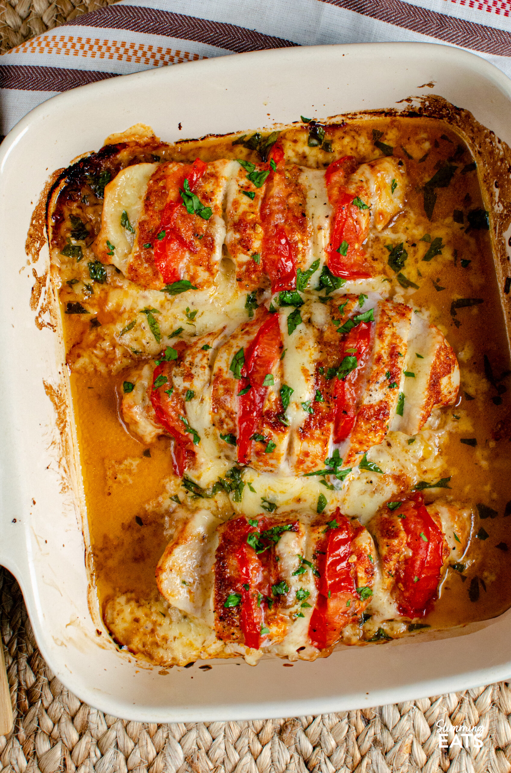 This Tomato Mozzarella Hasselback Chicken turns simple chicken breasts into an easy family dinner with juicy tomato and melted mozzarella. Three tomato and mozzarella stuffed hasselback chicken in a ceramic baking dish