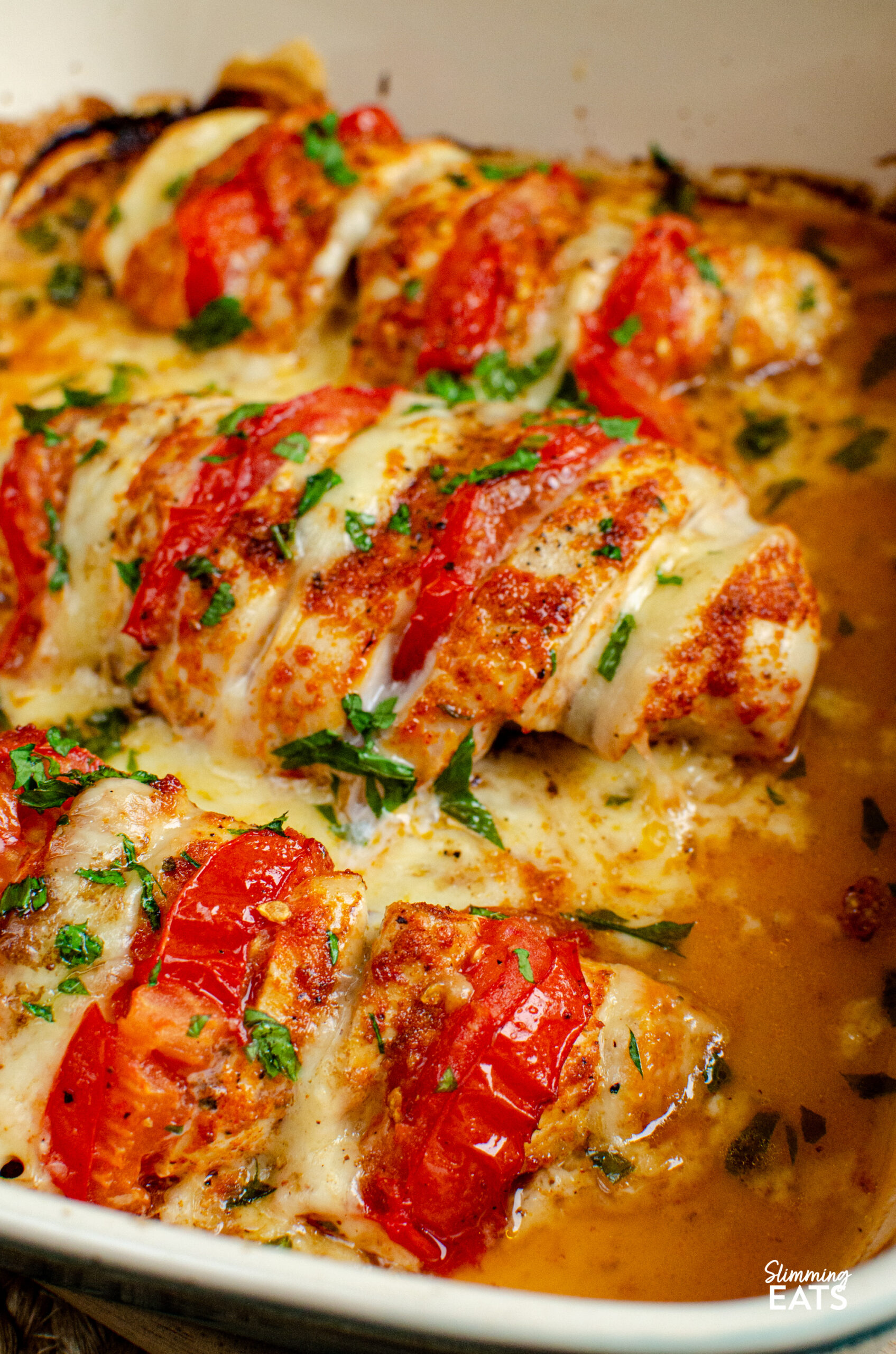 This Tomato Mozzarella Hasselback Chicken turns simple chicken breasts into an easy family dinner with juicy tomato and melted mozzarella. Three tomato and mozzarella stuffed hasselback chicken in a ceramic baking dish