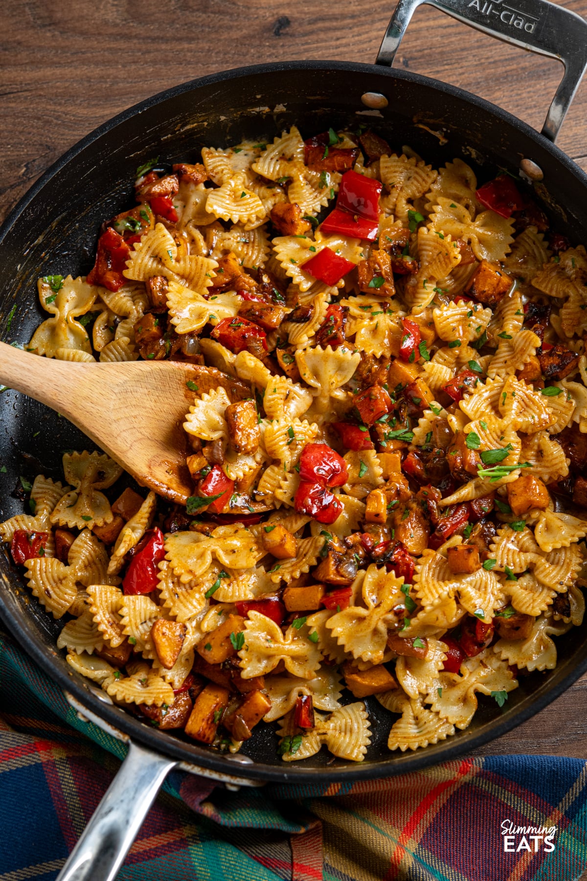 Roasted Butternut Squash and Red Pepper Pasta with Gruyere in a pan with wooden spoon