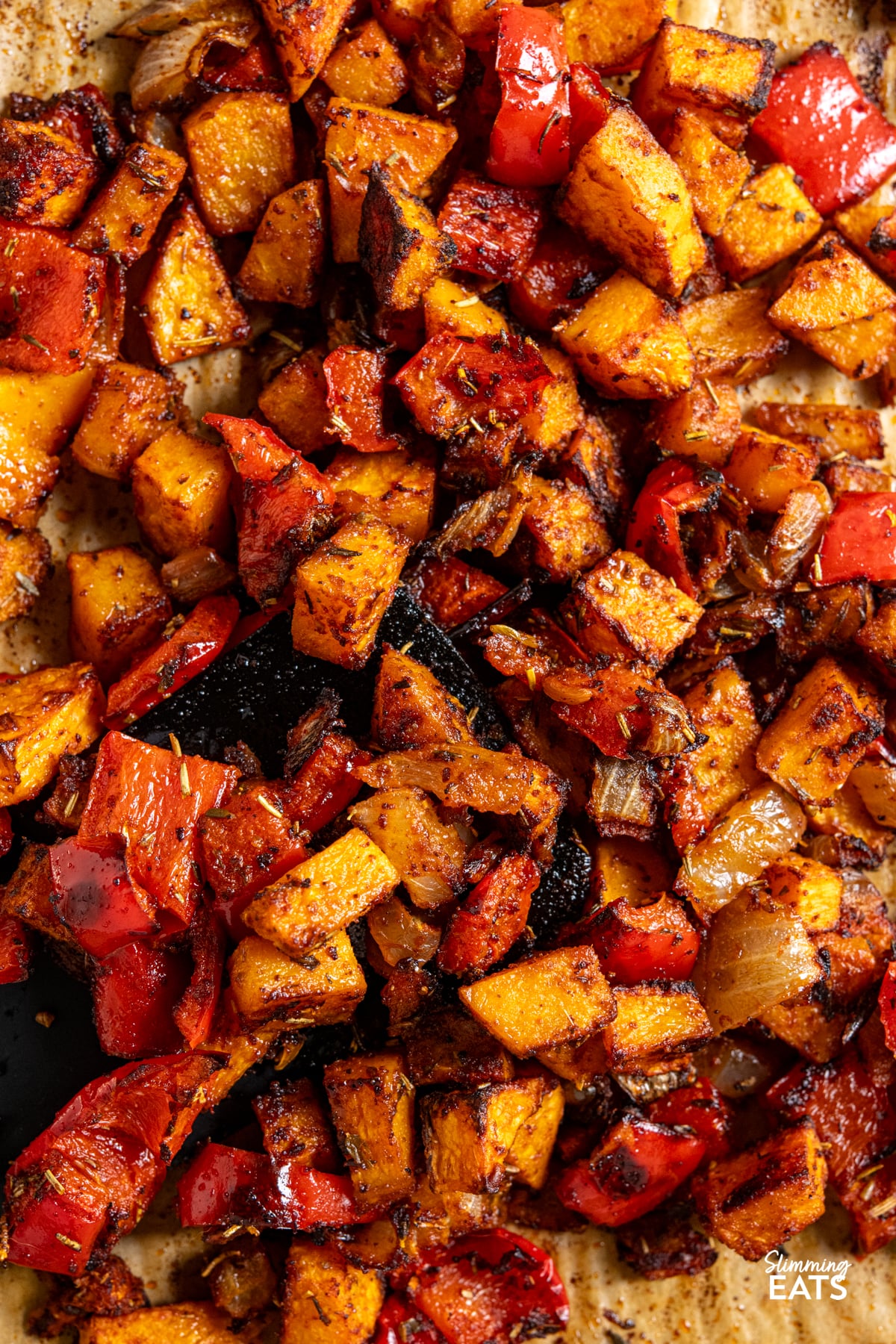 Roasted Butternut Squash and Red Pepper with onion and seasoning on a baking tray