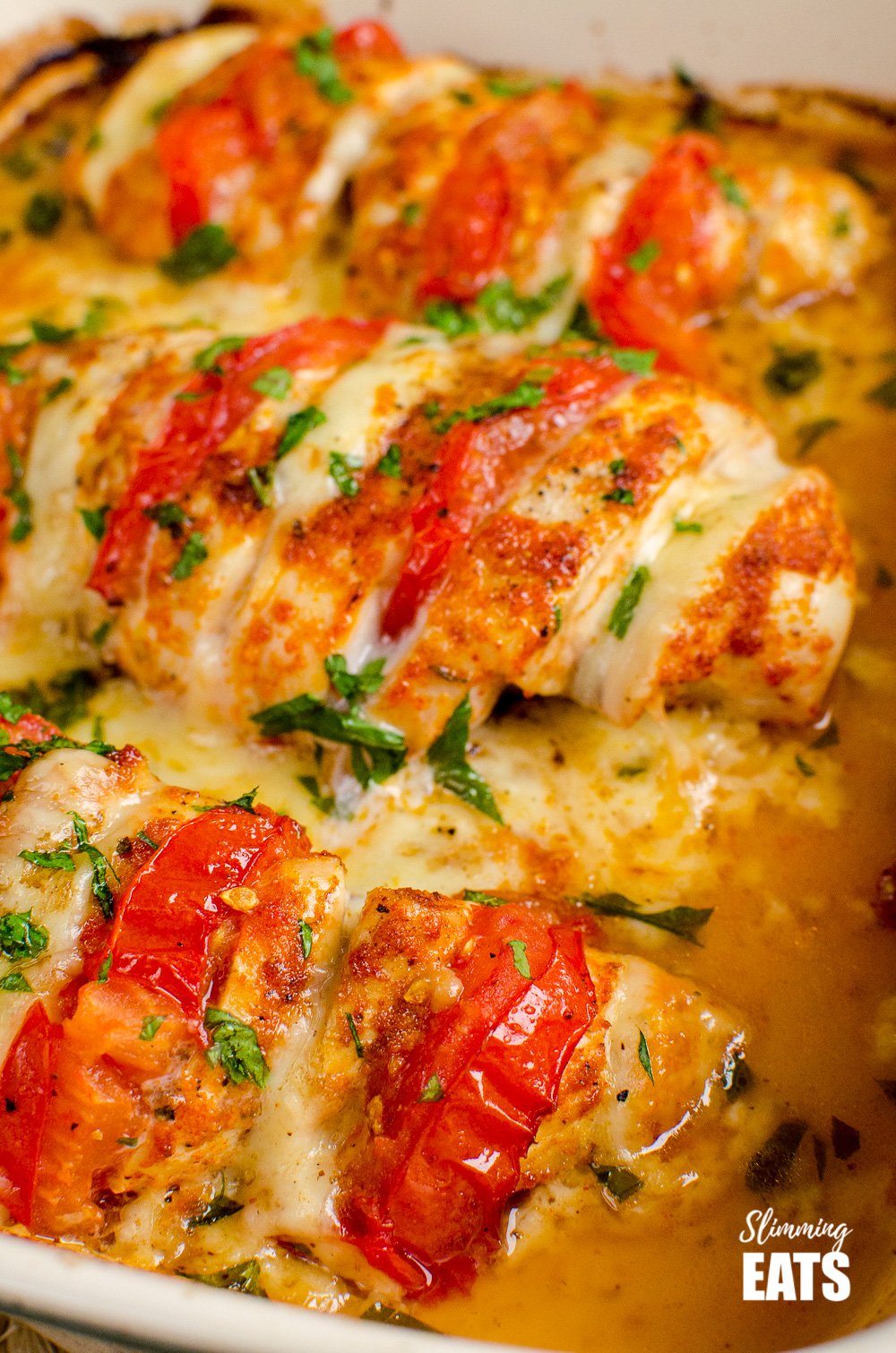 Cheesy goodness of Tomato and Mozzarella Hasselback Chicken - this is one chicken dish you just have to try. Gluten Free,Slimming and Weight Watchers friendly tomato and mozzarella hasselback chicken in oven proof dish