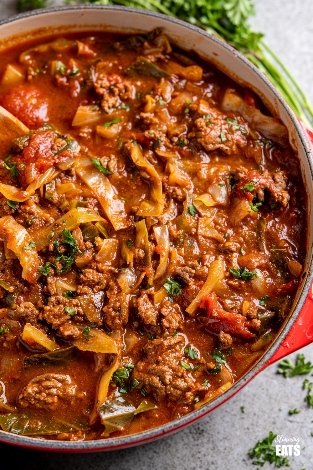 Hearty Beef and Cabbage Soup - a perfect comfort meal for all the soup lovers out there, simple ingredients, but amazing taste. Gluten free, dairy free, paleo, Whole30, Slimming Eats and Weight Watchers friendly close up of Beef and Cabbage Soup in cerise le creuset casserole pan