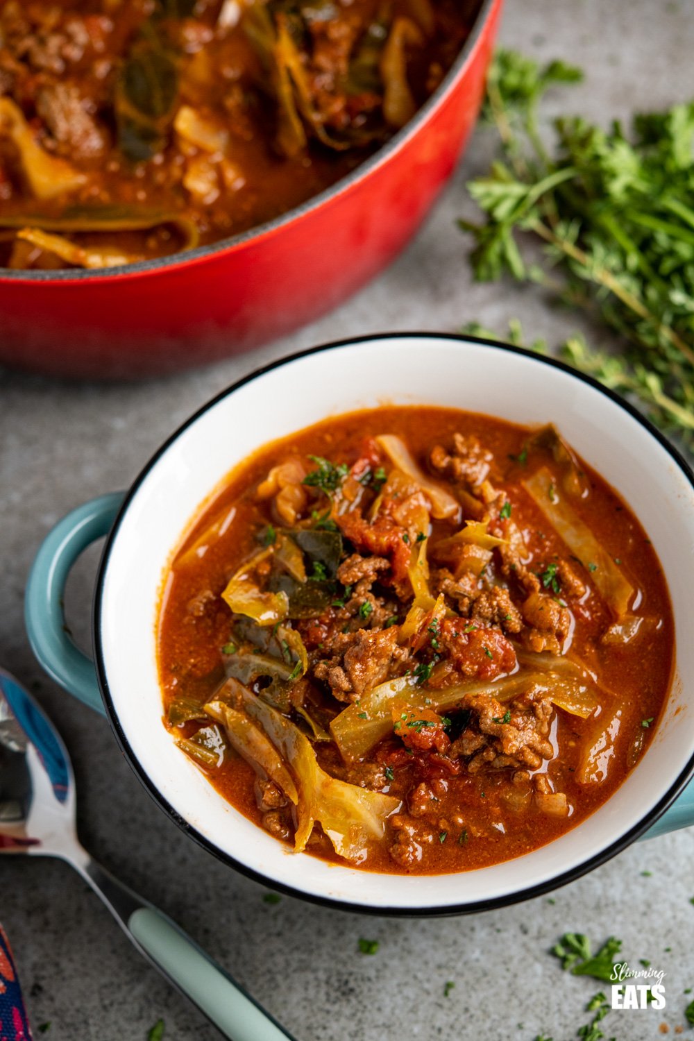 blue grey soup bowl filled with beef and cabbage soup