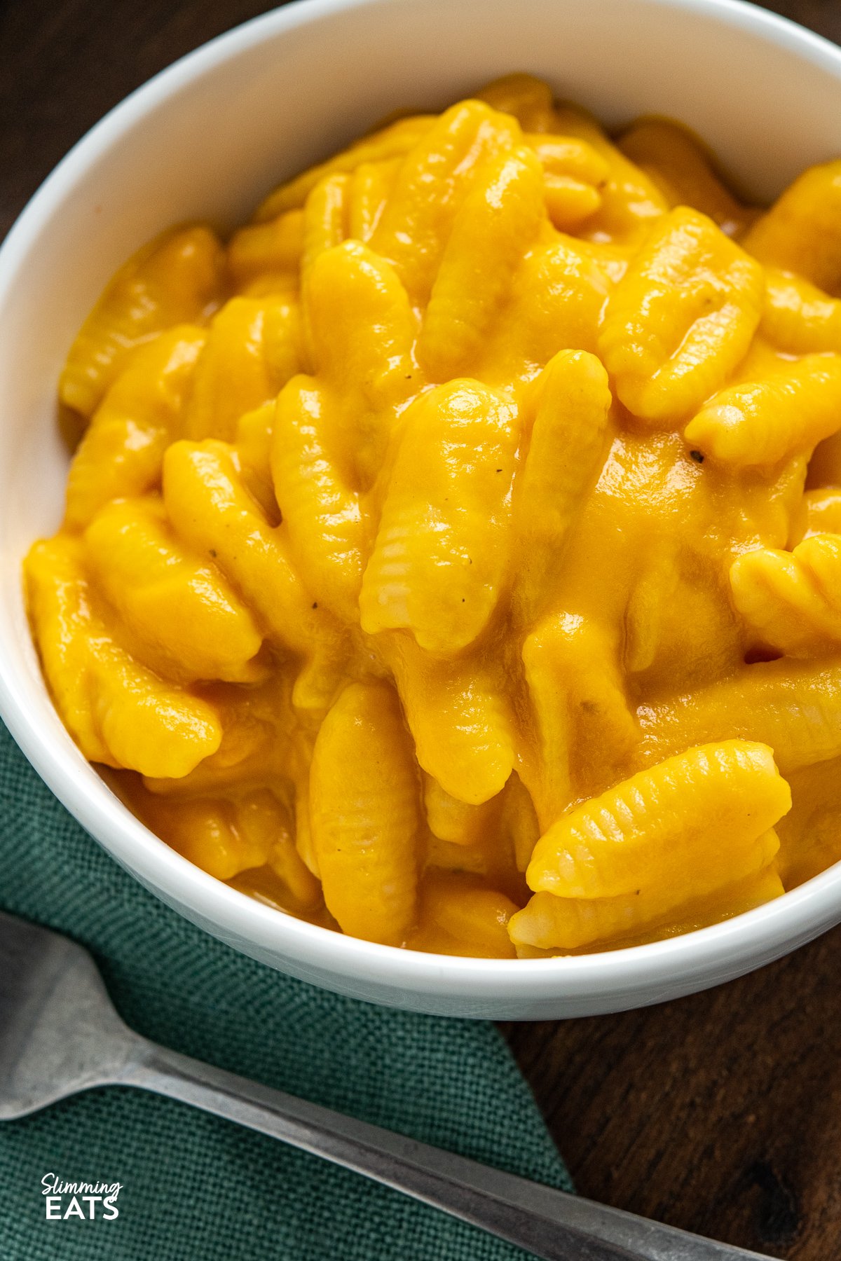 Close up of Creamy Butternut Squash Mac and Cheese in a white bowl on wooden board