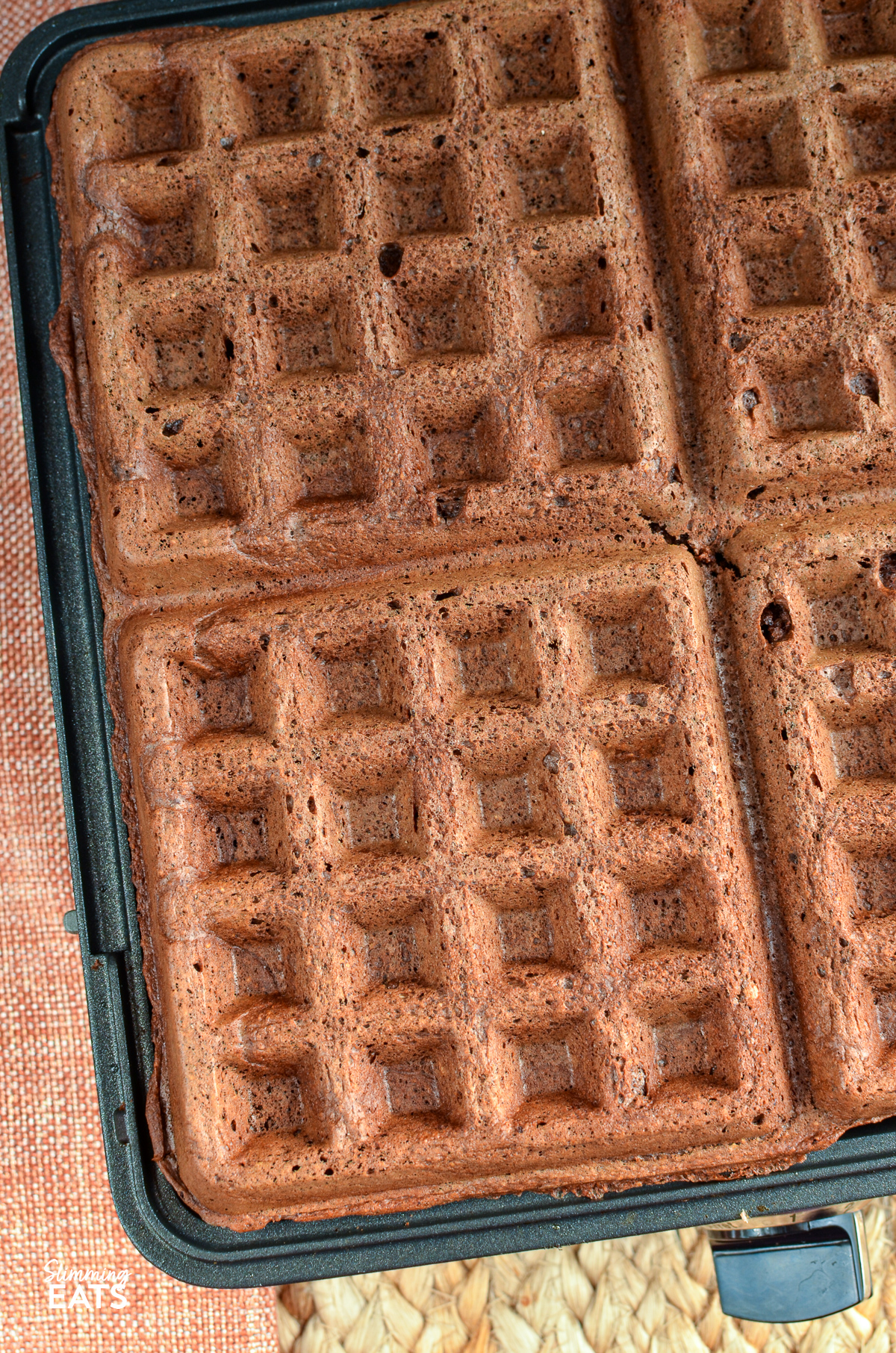 close up of Four square oat chocolate banana waffles freshly cooked and ready to be served.