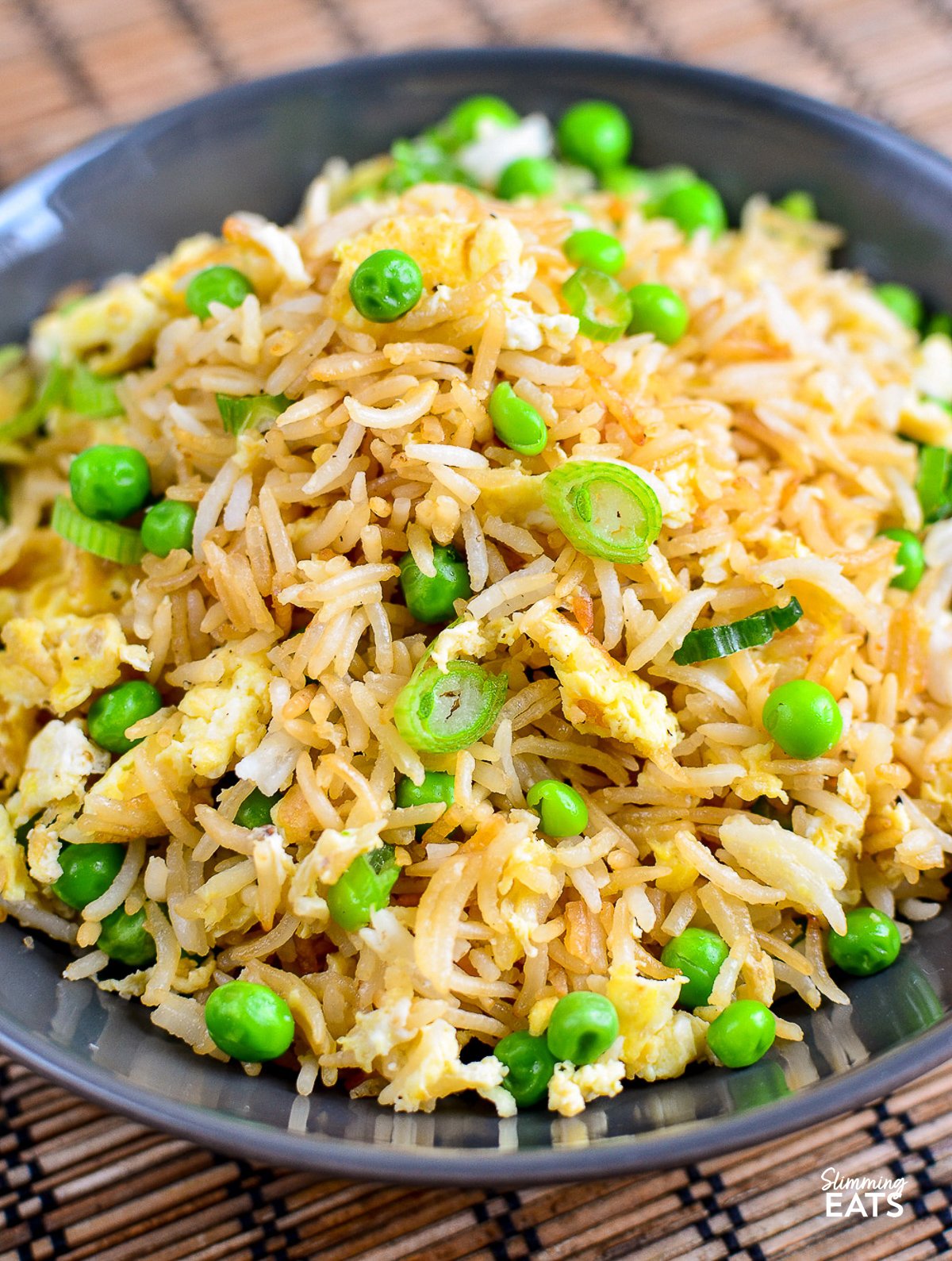 Perfect egg fried rice with peas and green onions in a bowl"