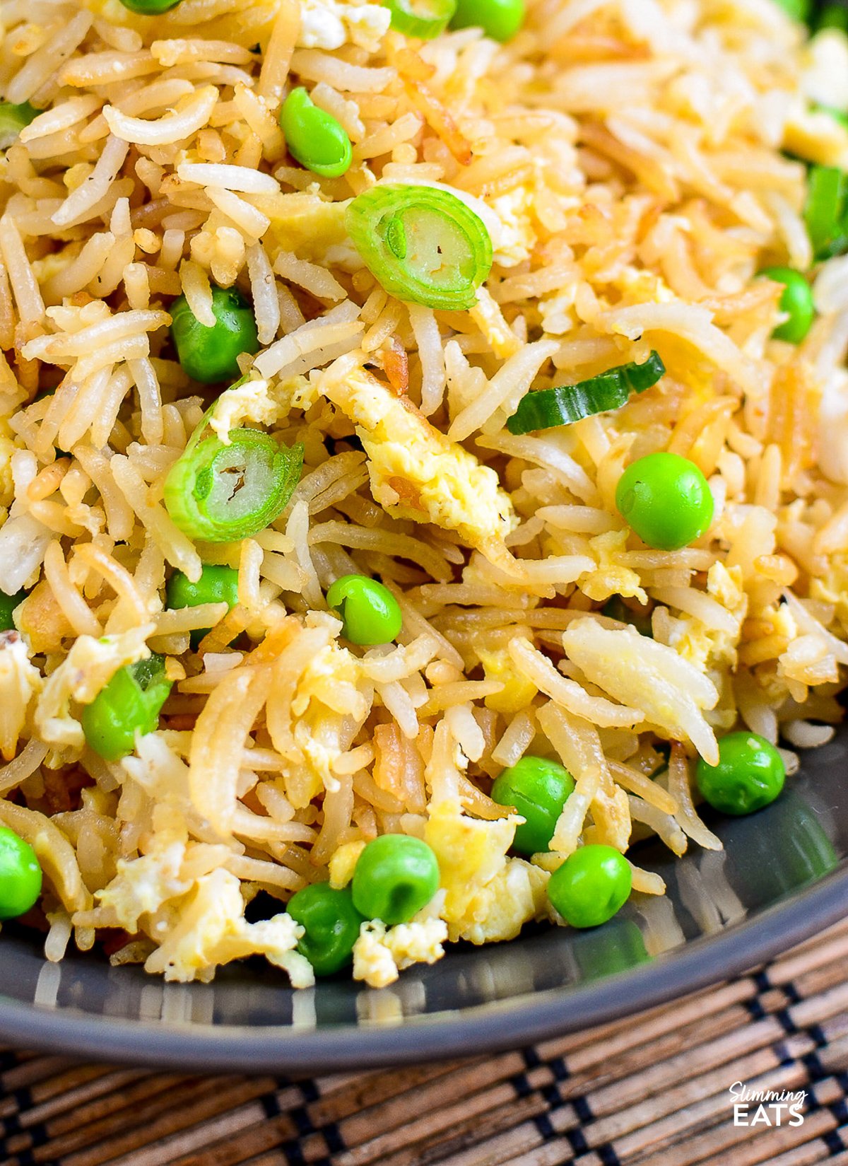 Perfect egg fried rice with peas and green onions in a bowl"