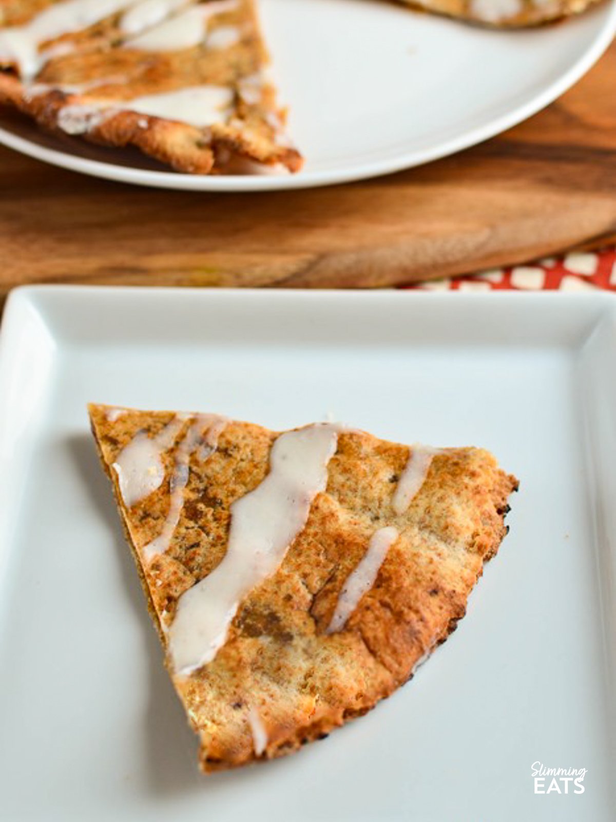 Golden crispy tortilla wraps filled with a delicious cinnamon sugar filling drizzled with a cream cheese icing. If you love cinnamon rolls - try these!! Cinnamon Roll Slice on white plate